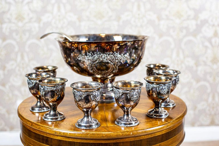 20th-century silver-plated punch bowl and cups

We present you this set composed of a bowl with a spoon and eight cups from before 1939.
The whole is silver-plated.

The items are in incredibly good condition. The surface is covered with