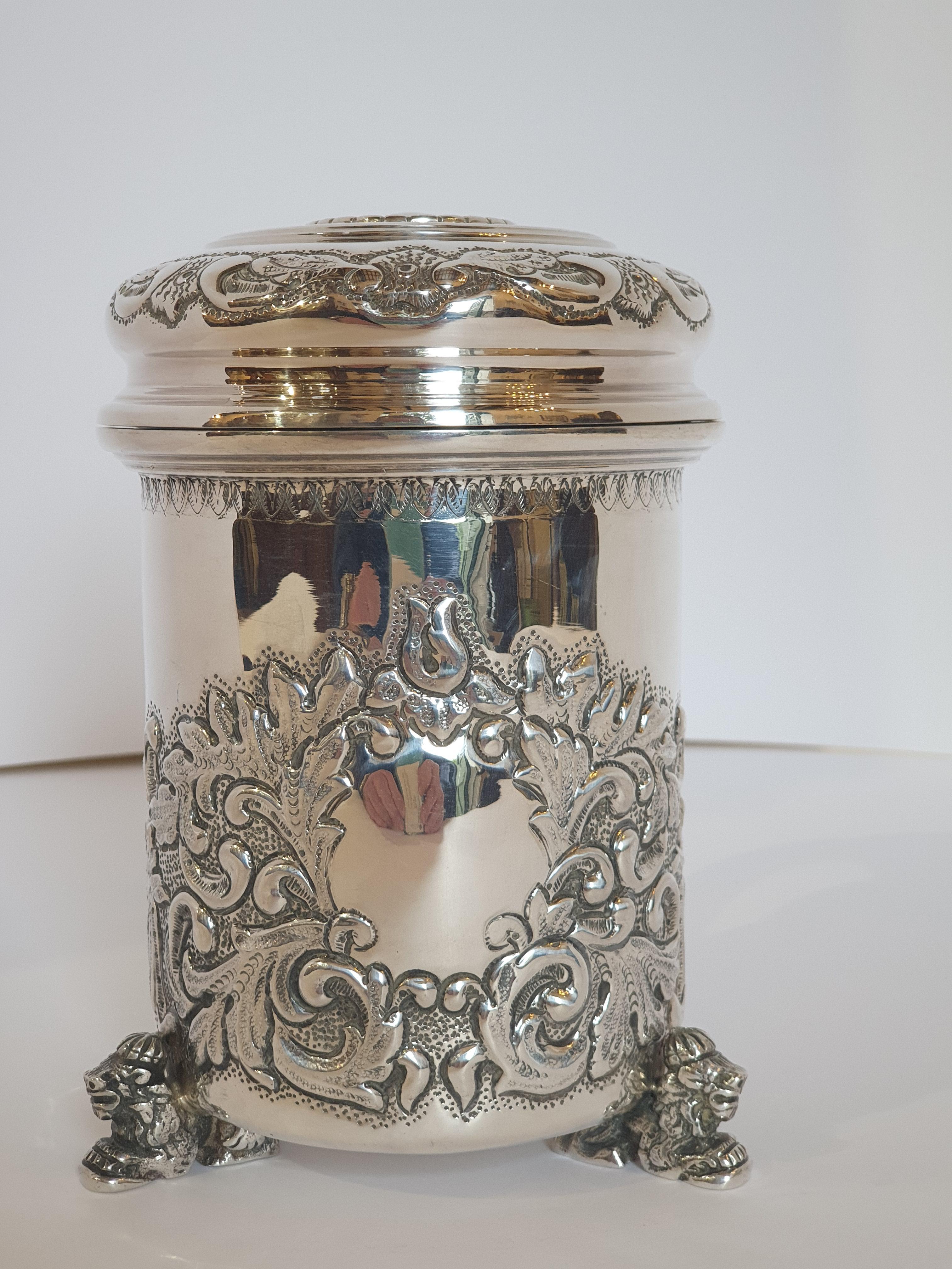 Magnificent tankard handcrafted in silver. This silver tankard is very intricately decorated with heavy repousse and chased metal work in a floral swag motif with a centralized cameo. The tree feet are done in figural seated lions and the finial are