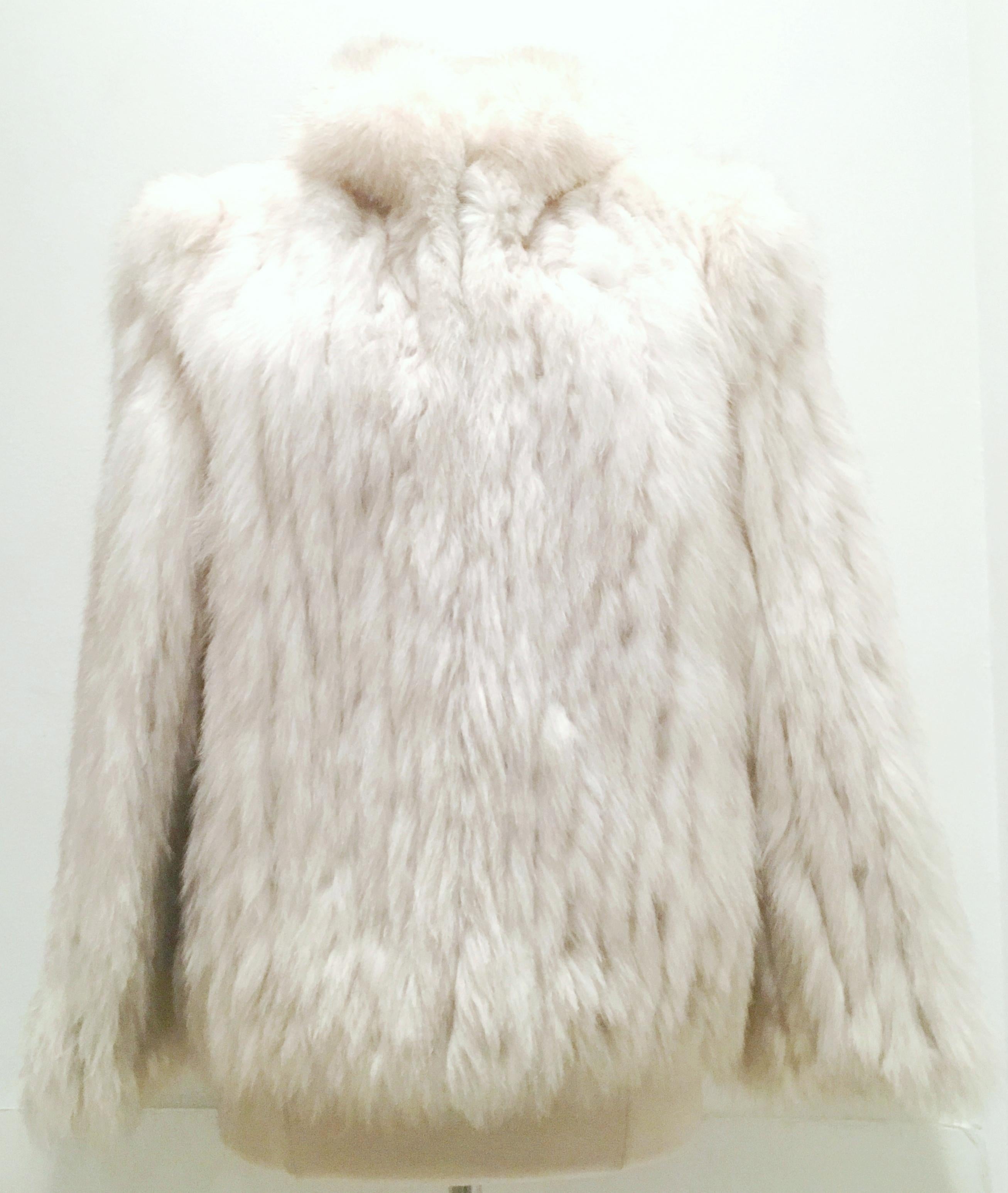 20th Century Silver Winter White Fox Fur Jacket By, Saga-Size Medium. This pristine Fox fur jacket features, two exterior side pockets and four invisible front closure hooks. Fully lined in silver satin with the original furrier tag in tact, Saga