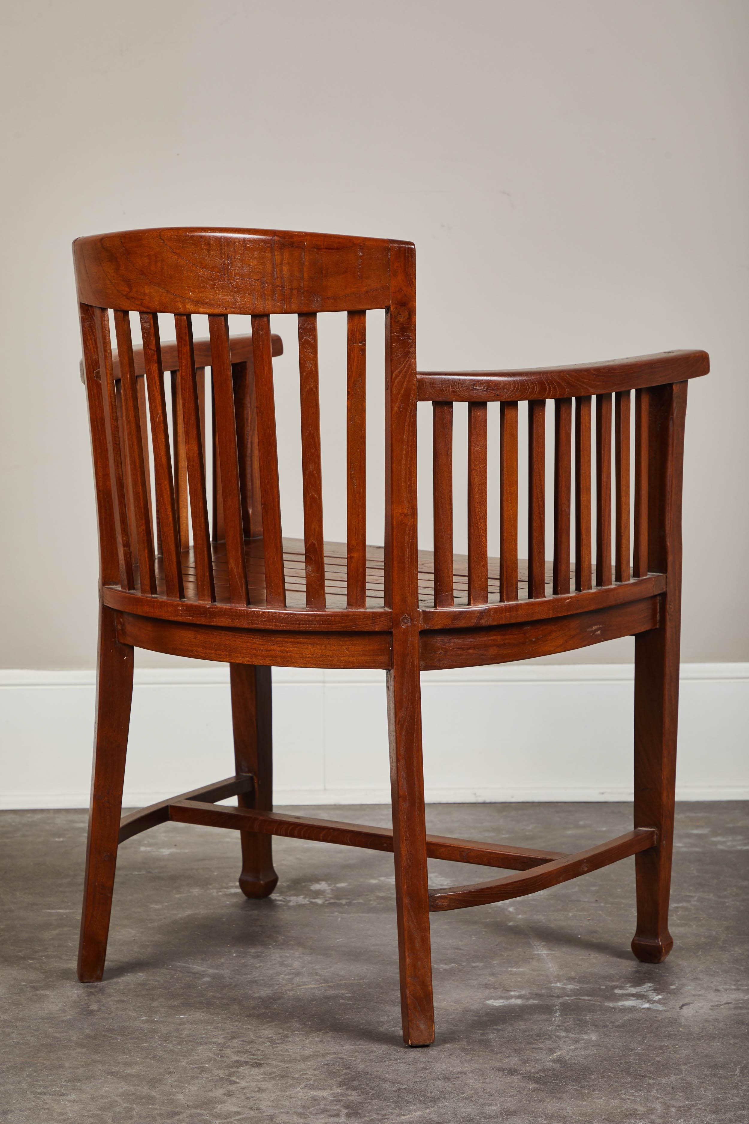 An early 20th century Indonesian desk chair made from teak. Slatted, curved back with a handmade and rustic quality to the overall shape. Great as occasional seating, or functional desk chair.