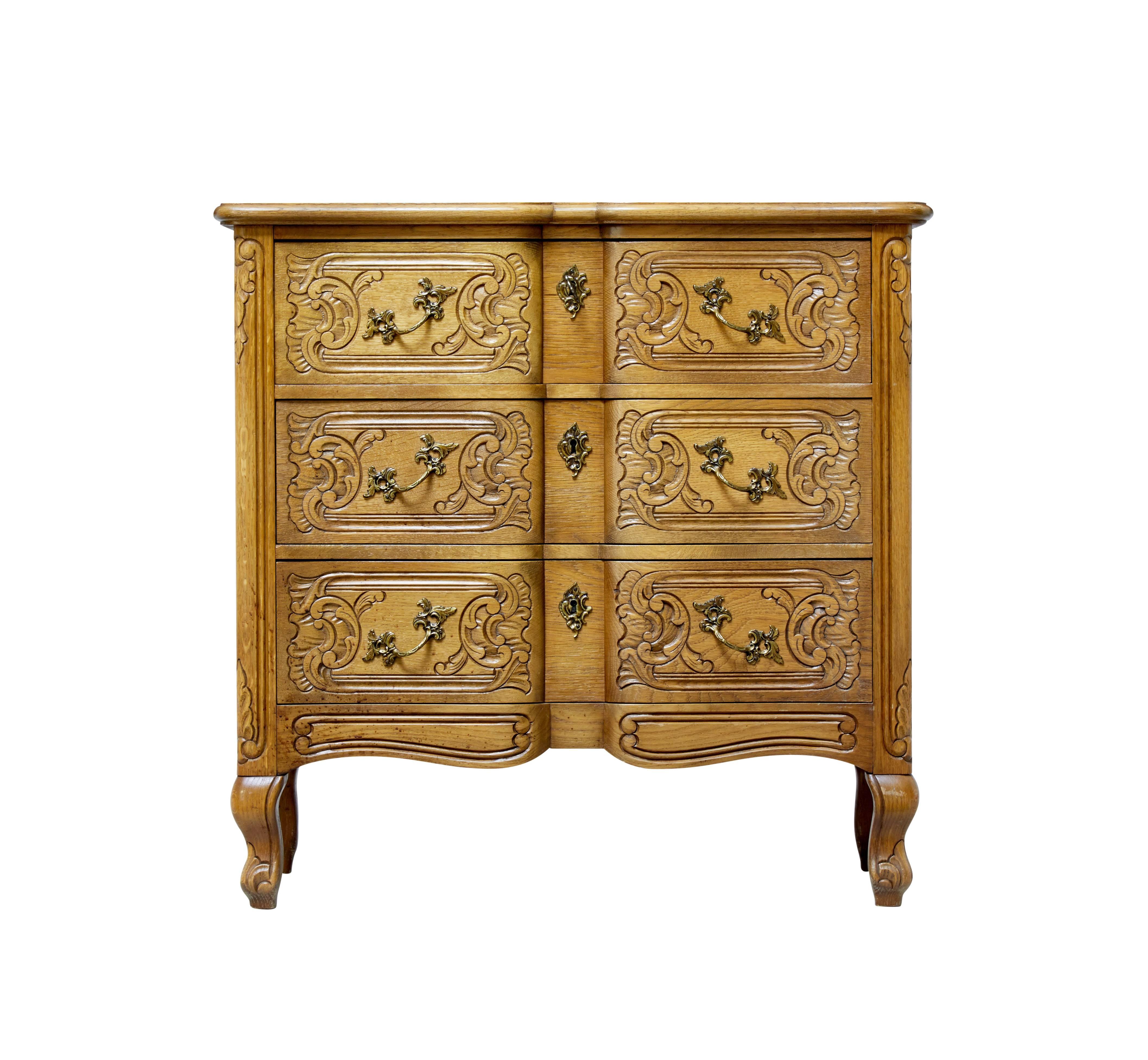 Carved oak commode of small proportions, circa 1950.

Practical small chest of drawers in the Baroque taste. Three block fronted drawers with carving in the solid. With decorative handles.

Light oak color.

Restoration to veneer on back edge.