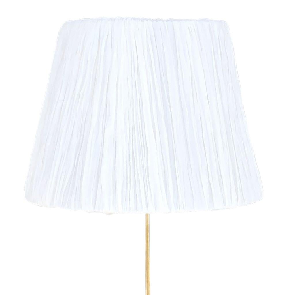 Eine kleine schwedische Stehlampe aus der Jahrhundertmitte mit weißem, rundem Schirm, aus handgefertigtem, poliertem Messing, mit einer Lichtfassung in gutem Zustand. Die skandinavische Leuchte wurde von Hans-Agne Jakobsson entworfen und von