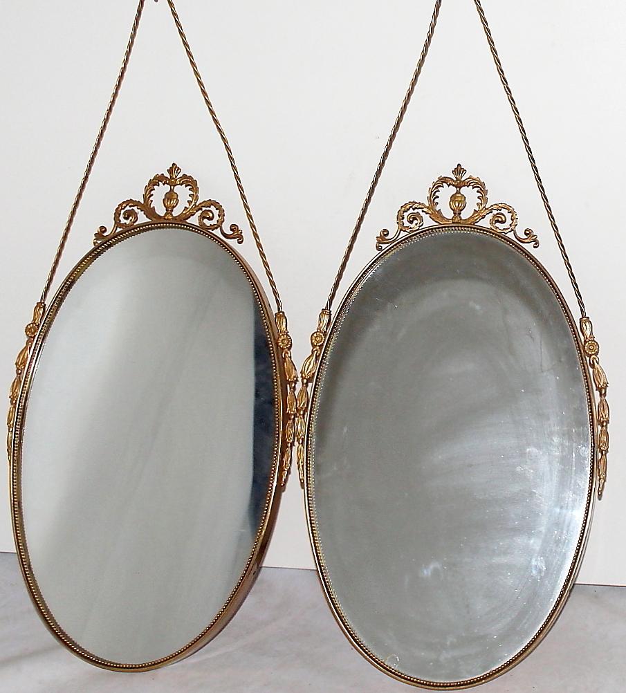 A small Swedish Art Deco pair of wall mirrors made of hand crafted brass and mirrored glass. The vintage pair is in good condition, enhanced by detailed brass décor. Minor losses on the original glass. Wear consistent with age and use. Circa 1930,