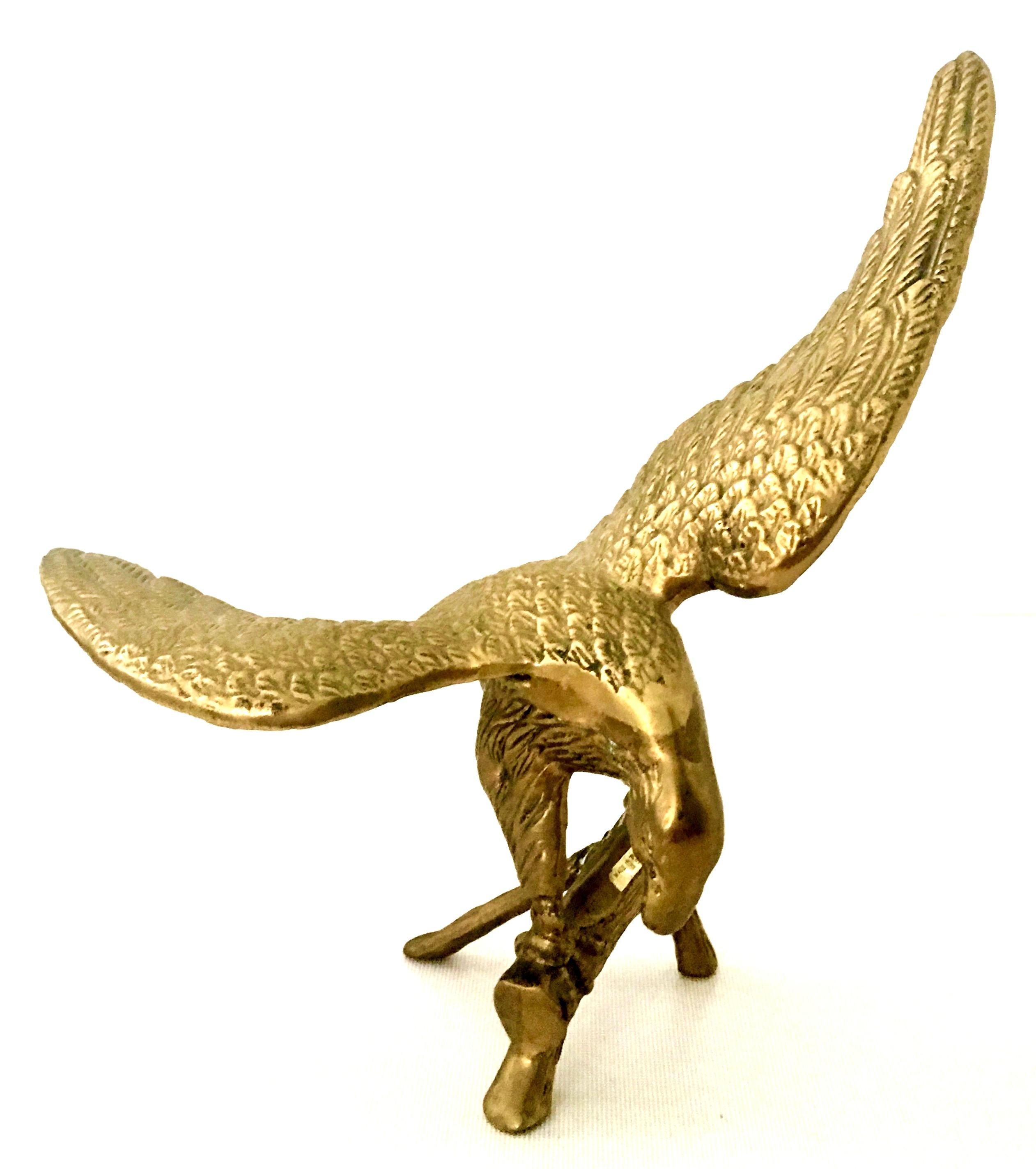 20th century polished solid brass perched eagle sculpture. Features a finely crafted and expertly detailed eagle about to take flight perched on a faux bois tree branch.
  