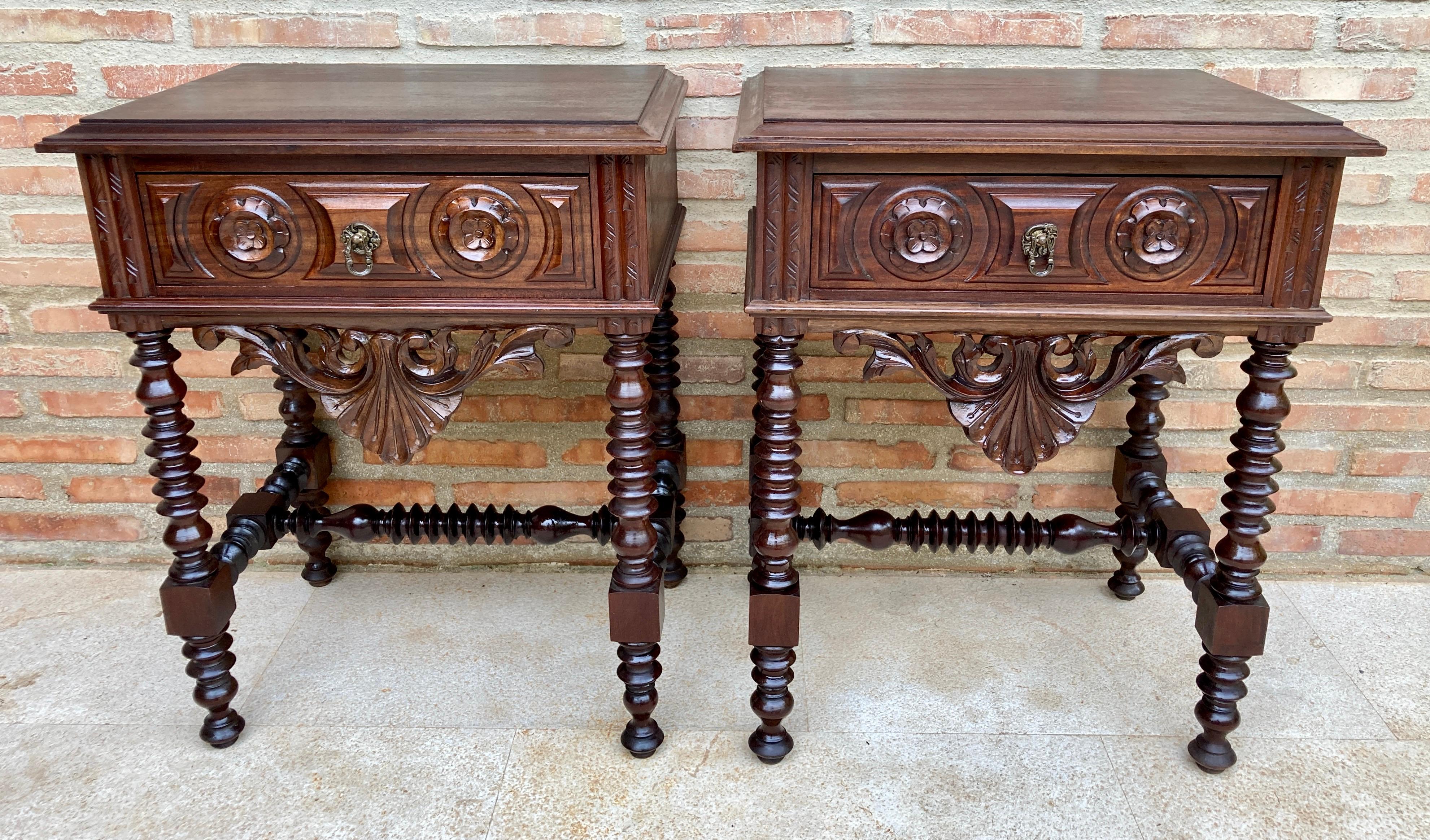 20th century pair of solid carved French nightstands with turned columns and stretcher. 
It has one carved drawer with foliate reliefs and original hardware. 
French Provincial 
Light wear consistent with age and use, Completely restored.