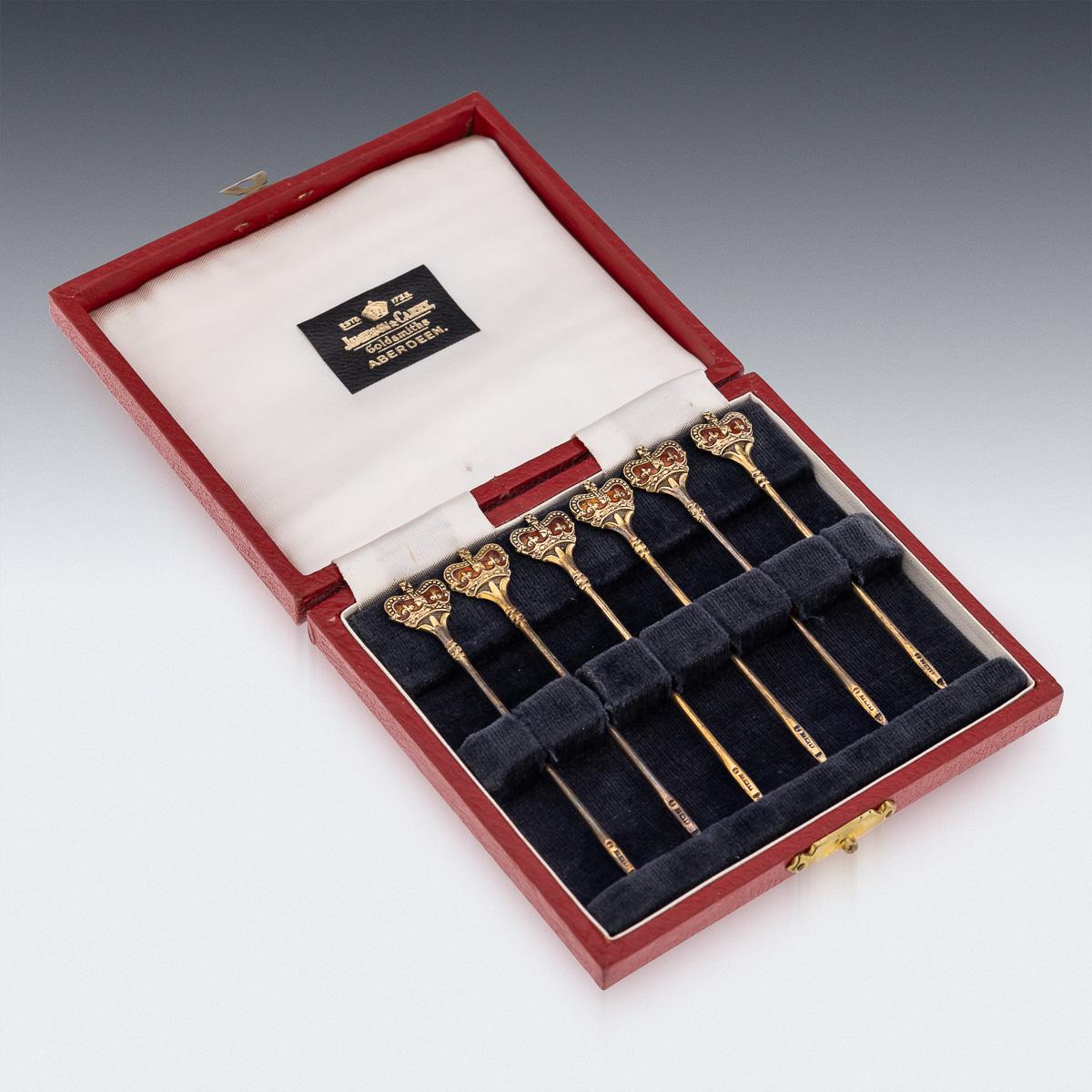 Mid 20th Century British solid silver-gilt set of six cocktail picks, decorated with enamels depicting royal crowns. The set comes in its original leatherette and velvet lined box. Each piece is Hallmarked English silver (925 Standard), Birmingham,