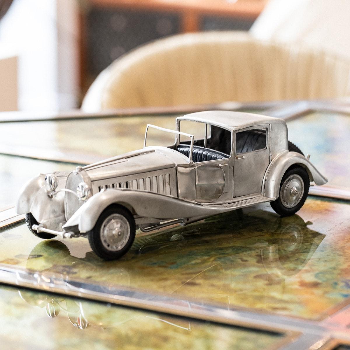 Modèle élégant d'une Bugatti Type 41, mieux connue sous le nom de Bugatti Royale, datant du milieu du 20e siècle. Ce modèle est fabriqué à partir de près de 3 kilogrammes d'argent massif avec la plus grande attention aux détails. La voiture est