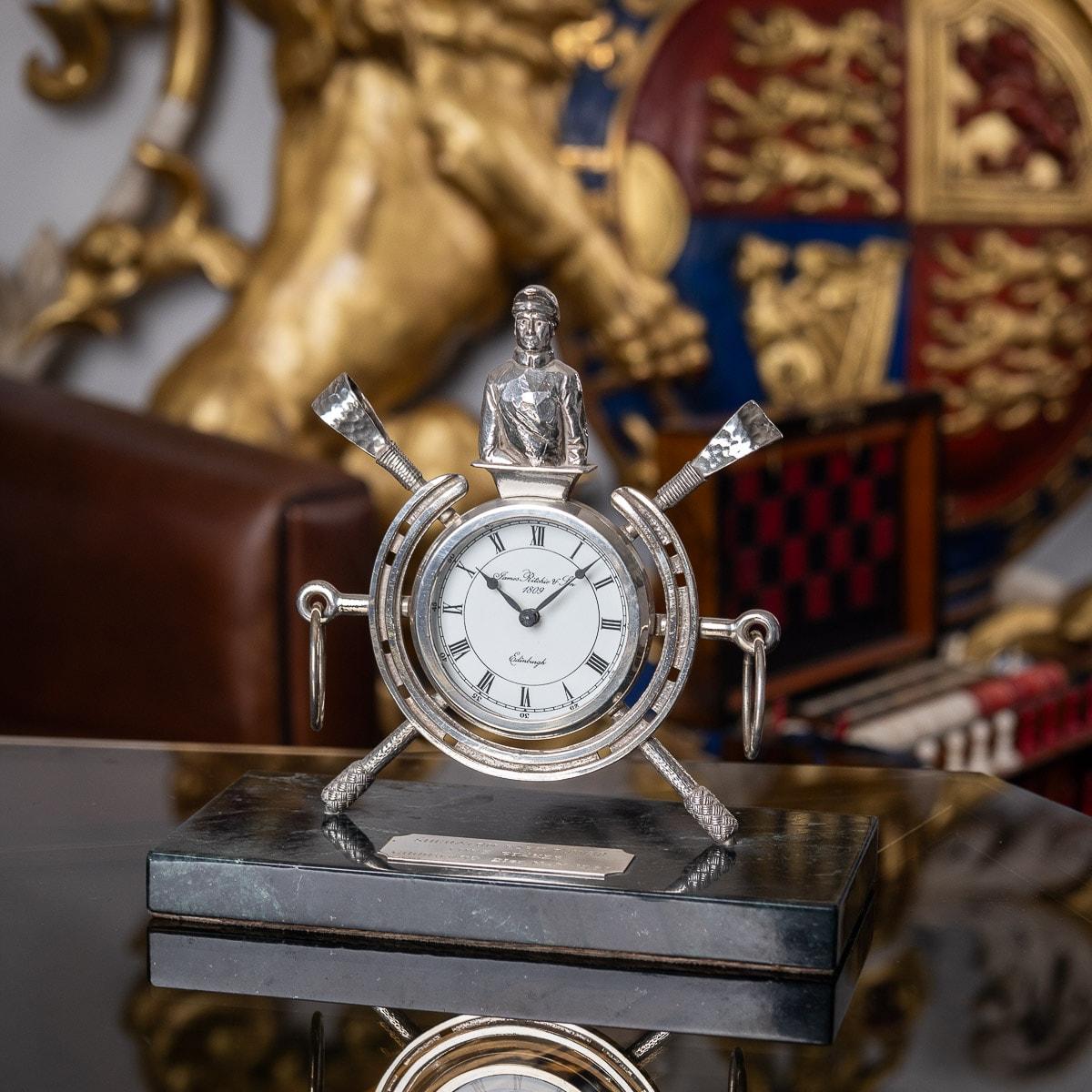 Unusual 20th century solid silver clock on green marble base, the clock set between a horse-shoe and mounted with a jockey, stirrups and riding crops. The clock is in fully working order and base engraved 'Sheraton Park Tower, Lupe Stakes, Goodwood,