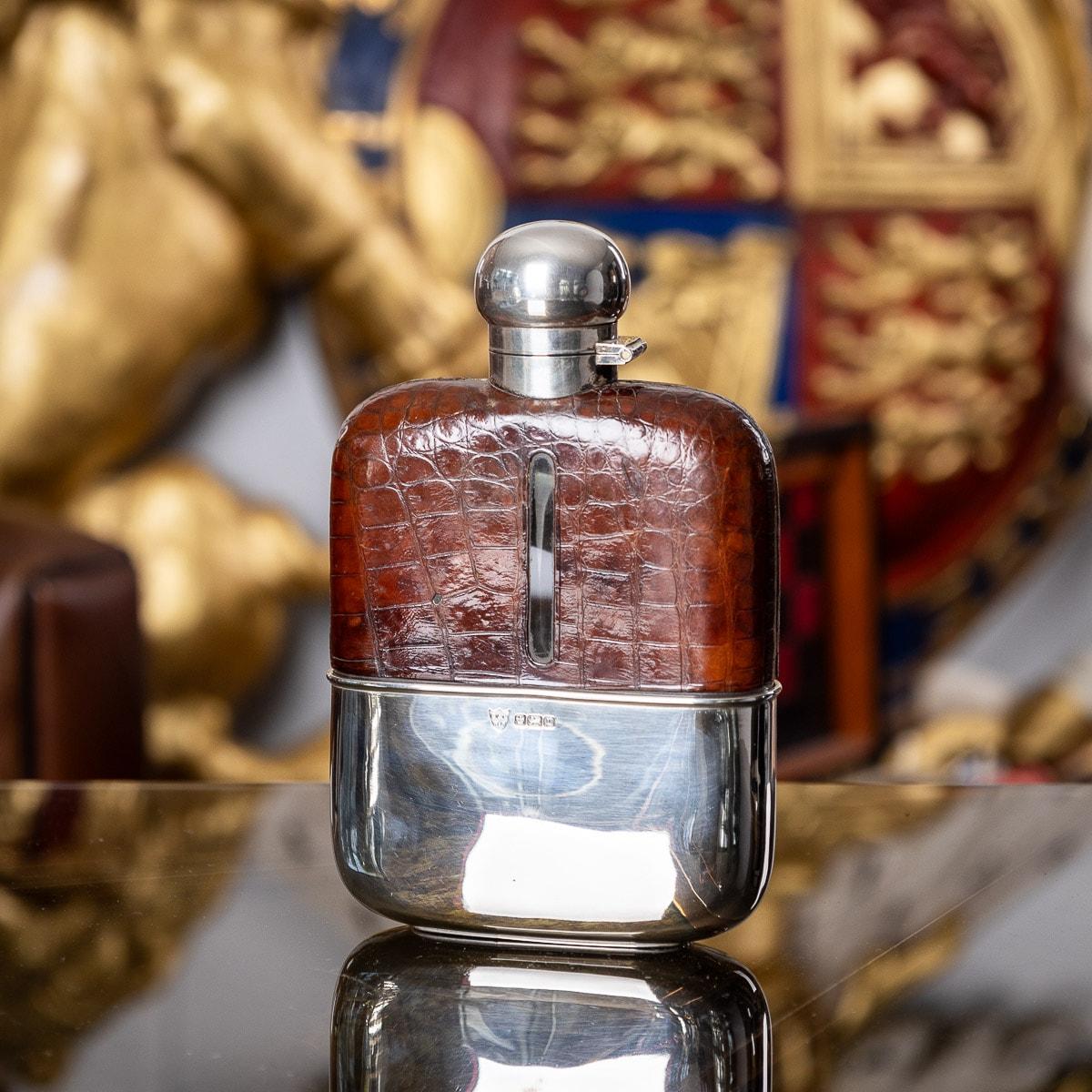 Antique early-20th Century Edwardian solid silver, blown glass and bound in sumptuous crocodile leather hip flask, unusually large, of rounded rectangular form, with a pull off cup, top mounted with a large hinged lid. Hallmarked with English silver