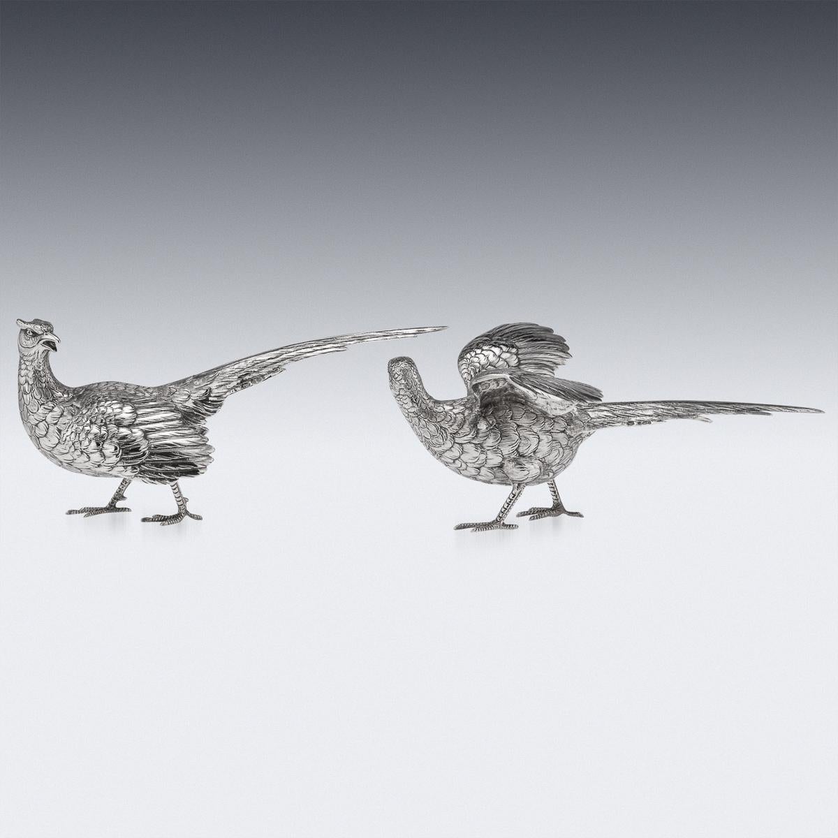 20th century pair of silver table ornaments modelled as a male and female pheasants, each statue is naturalistic and well-refined, perfect to use as a table or fireplace ornament, the heads are set turned and one with raised wings. Hallmarked