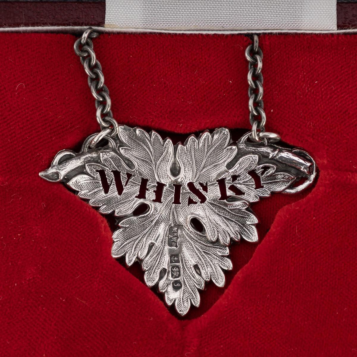 Late 20th Century set of five solid silver spirit labels, each beautifully modelled and chased imitating a wine leaf and pierced to spell out the drink of choice, suspended on a silver chain, presented in the original retail box. Each label is