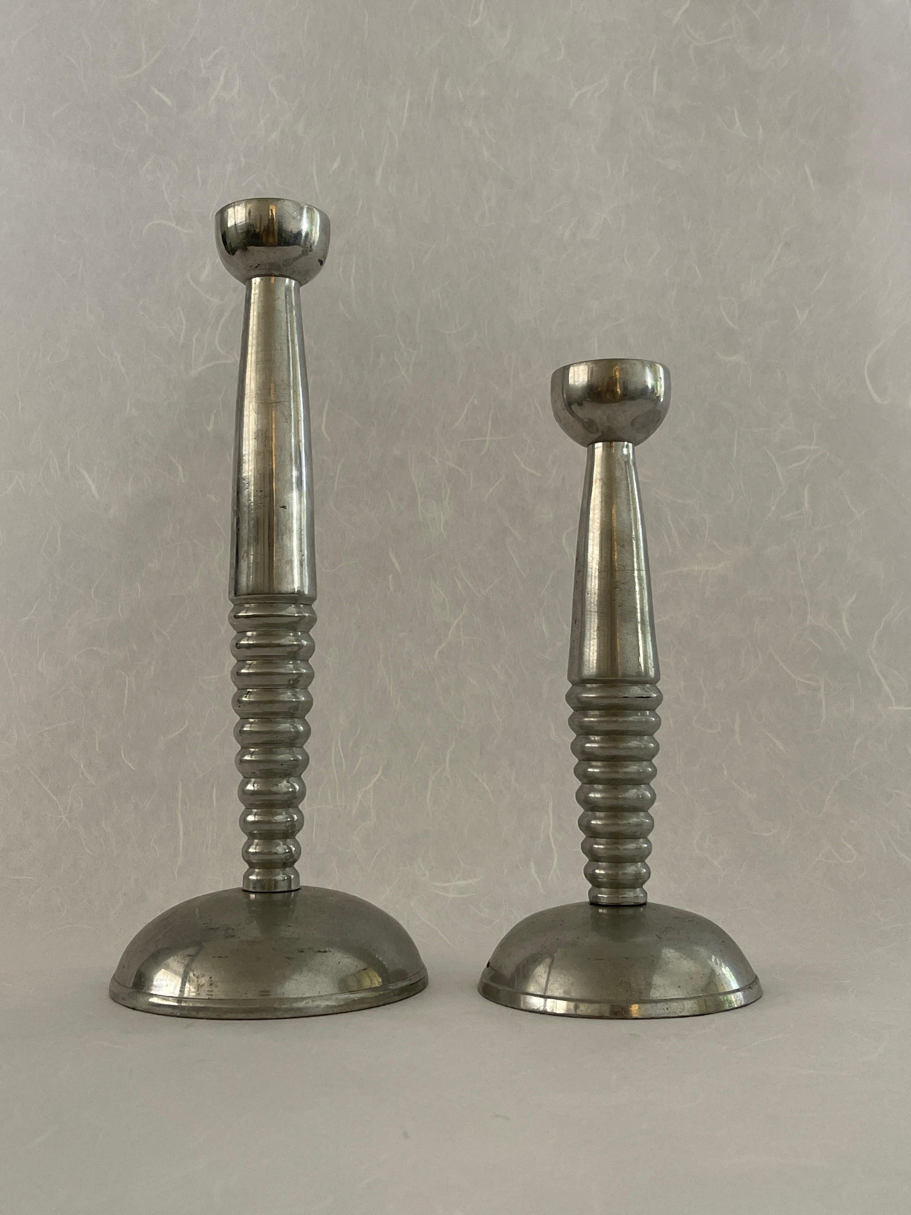 20th Century Space Age Silver Candle Stick Holders with a wide a circular base and a half ribbed shaft and fluted top. Great design with a good heavy weight. Sold as a pair. Two different sized holders. 
