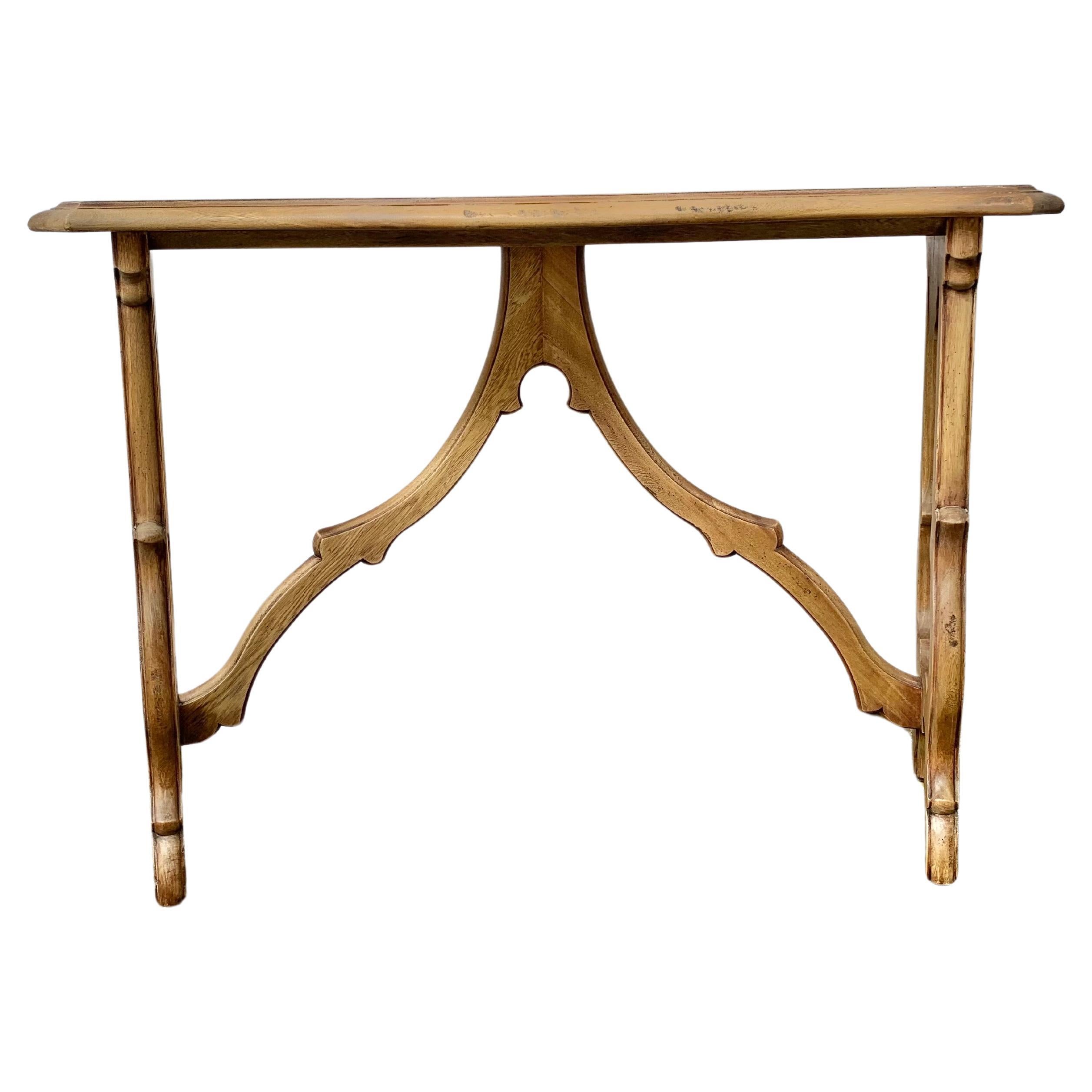 This 20th Century Spanish Baroque Style Console Table was crafted from Oak in the 1900's. The console table features a rectangular serpentine shaped top resting on two beautifully carved lyre shaped legs adjoined by center cross stretchers. The back