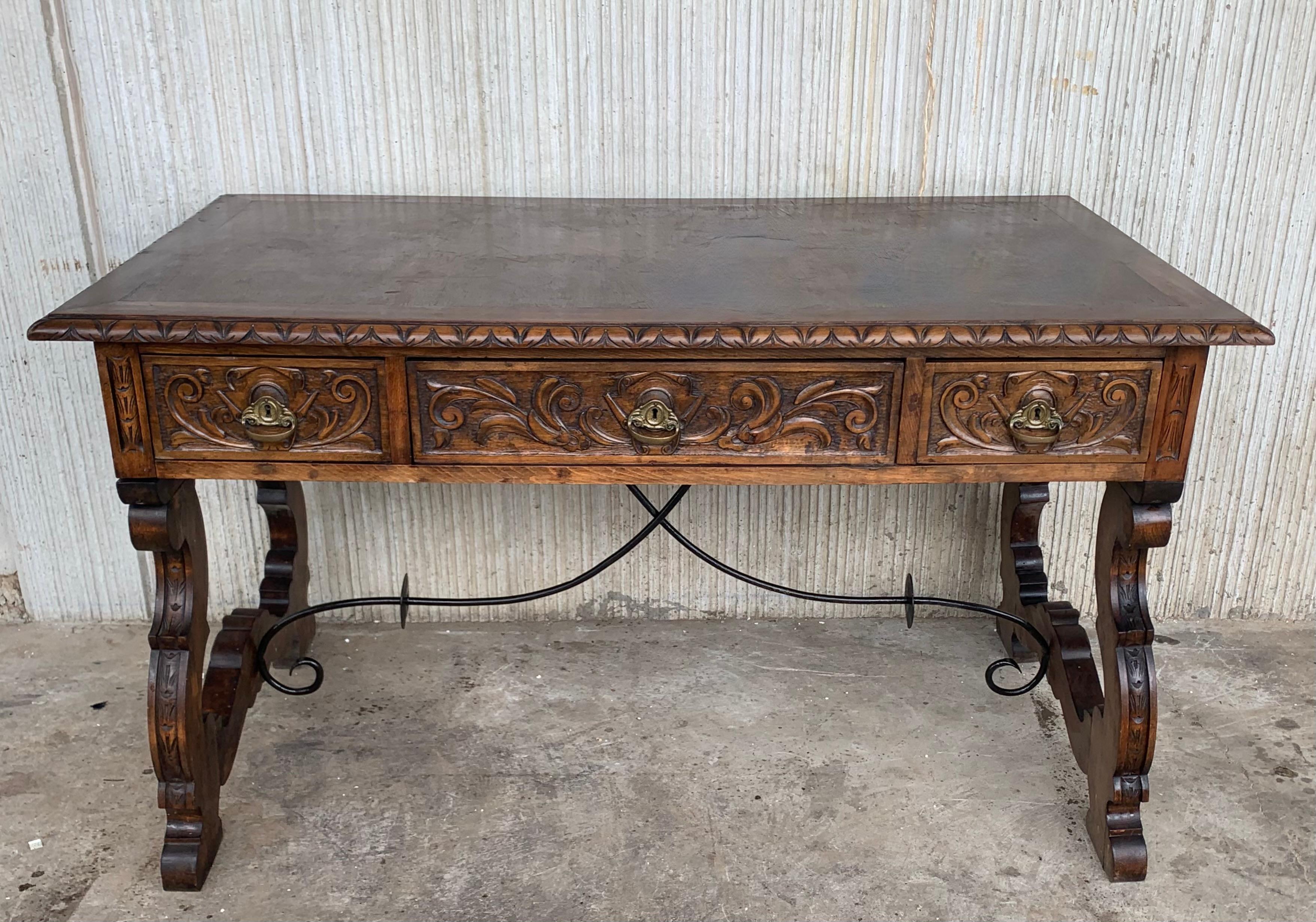 Handsome oak library piece that can be used as a desk or work table. Made of oak having carved gadrooned edges. A stretcher made of wood. Carved on all sides and three drawers, early 20th century.
Workable locks and key.

Measures: Height to the