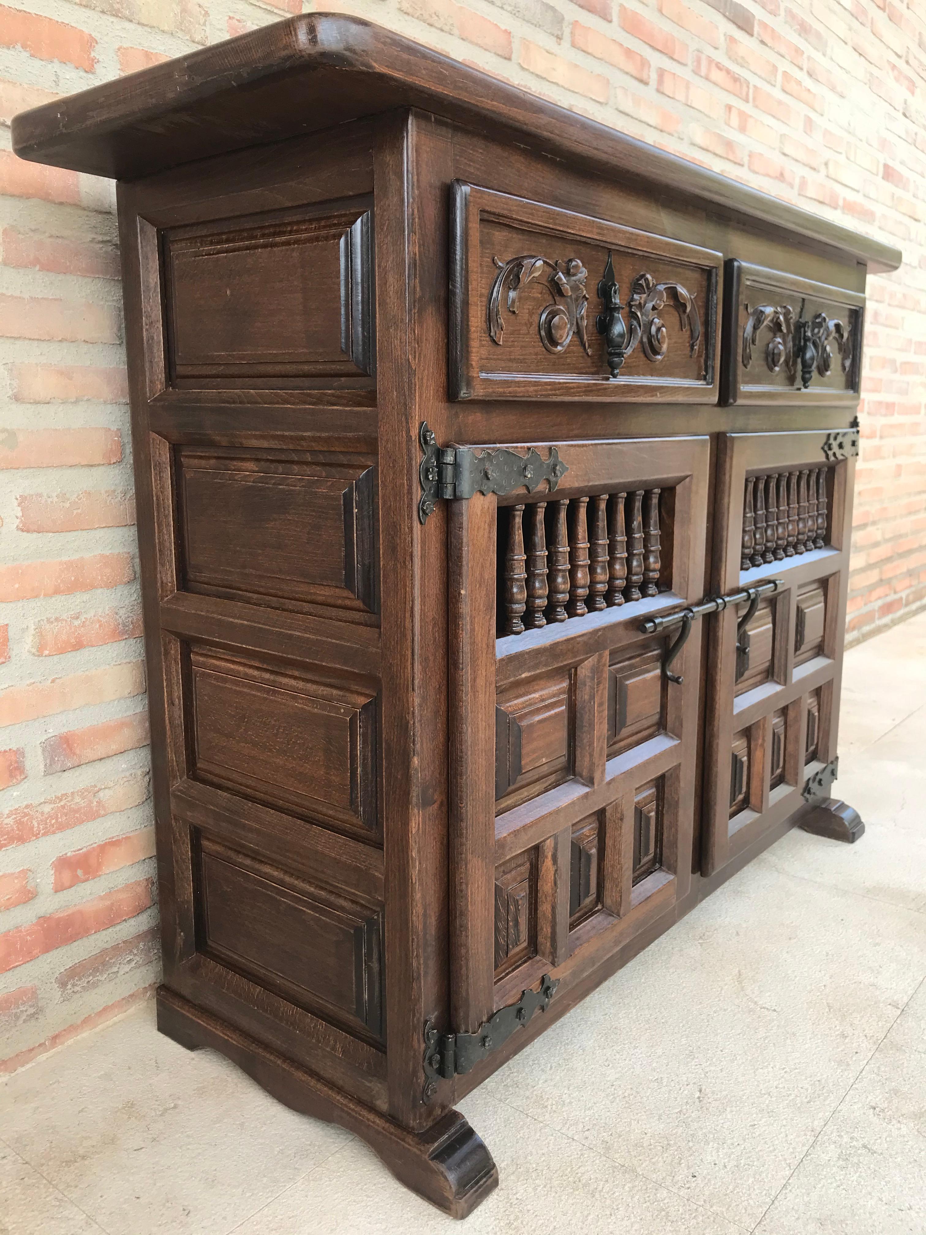 From Northern Spain, constructed of solid walnut, the rectangular top with molded edge atop a conforming case housing two drawers over two doors, the doors panelled with solid walnut, raised on a plinth base.

 