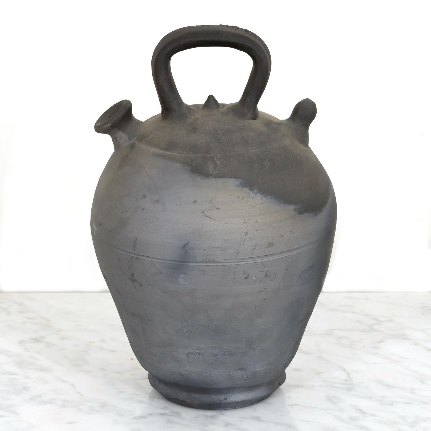 An early 20th century barro negro or black clay botijo, hand made and signed ROCA CAUS VERDU on the handle, by the famed pottery company, Roca Caus, in the village of Verdú in the Catalan region of Spain, circa 1900. This beautiful utilitarian pot,