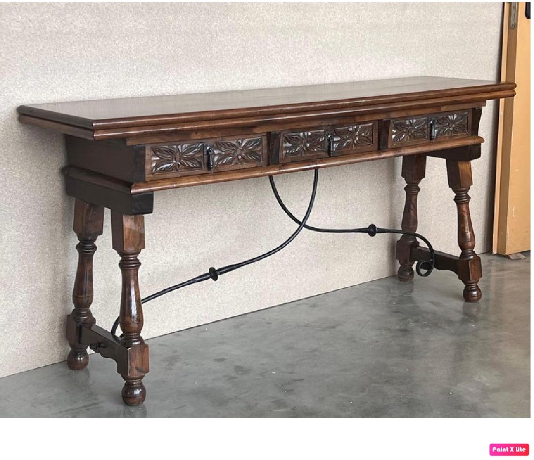 20th century Spanish console fold out farm table with three carved drawers and iron stretcher
Works as both a dining table and console.

Completely restored and waxed

Open measurements: 33in x 63in.
 