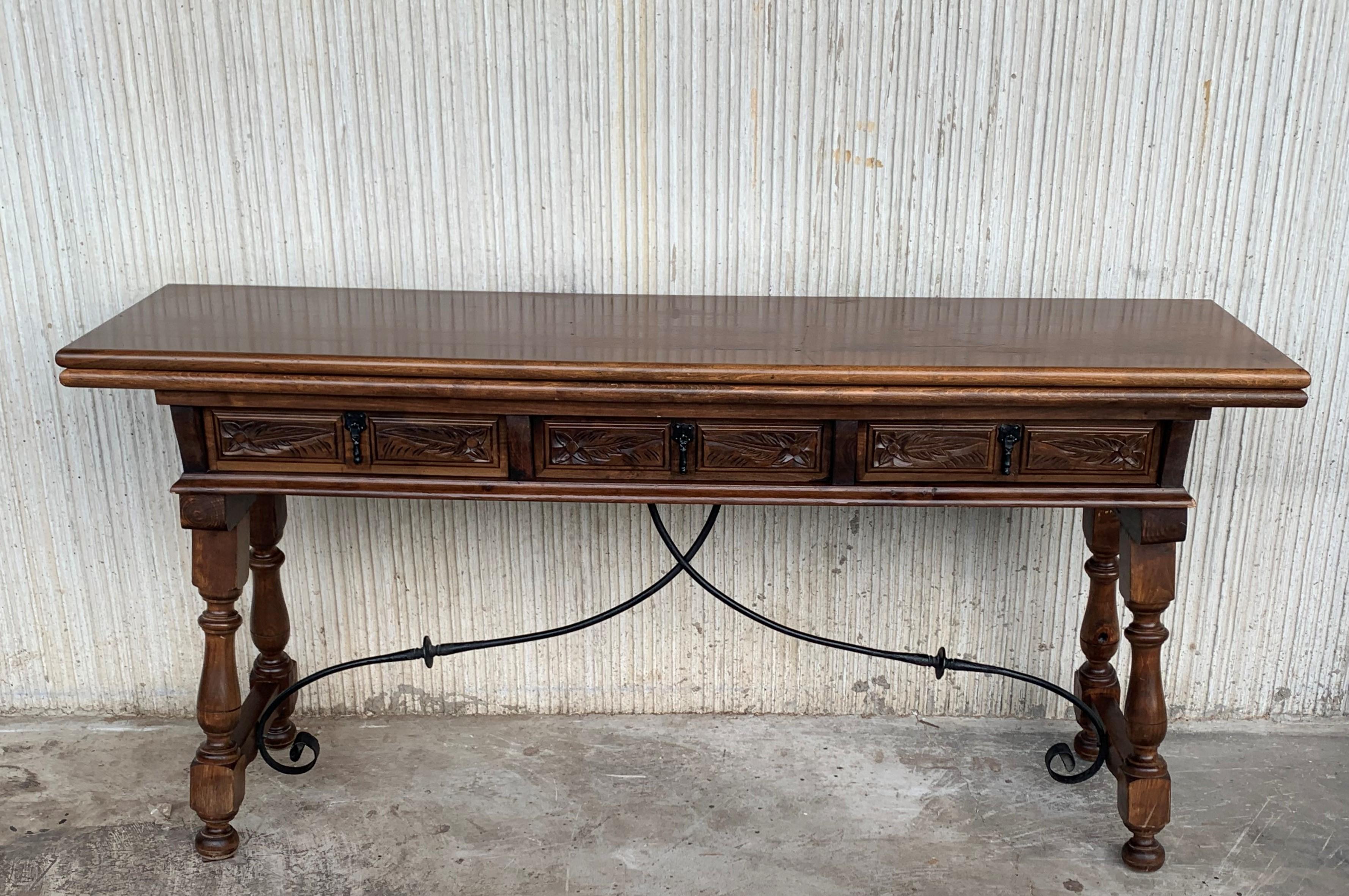 20th century Spanish console fold out farm table with three carved drawers and iron stretcher
Works as both a dining table and console.

Open measurements: 33in x 63in.
  