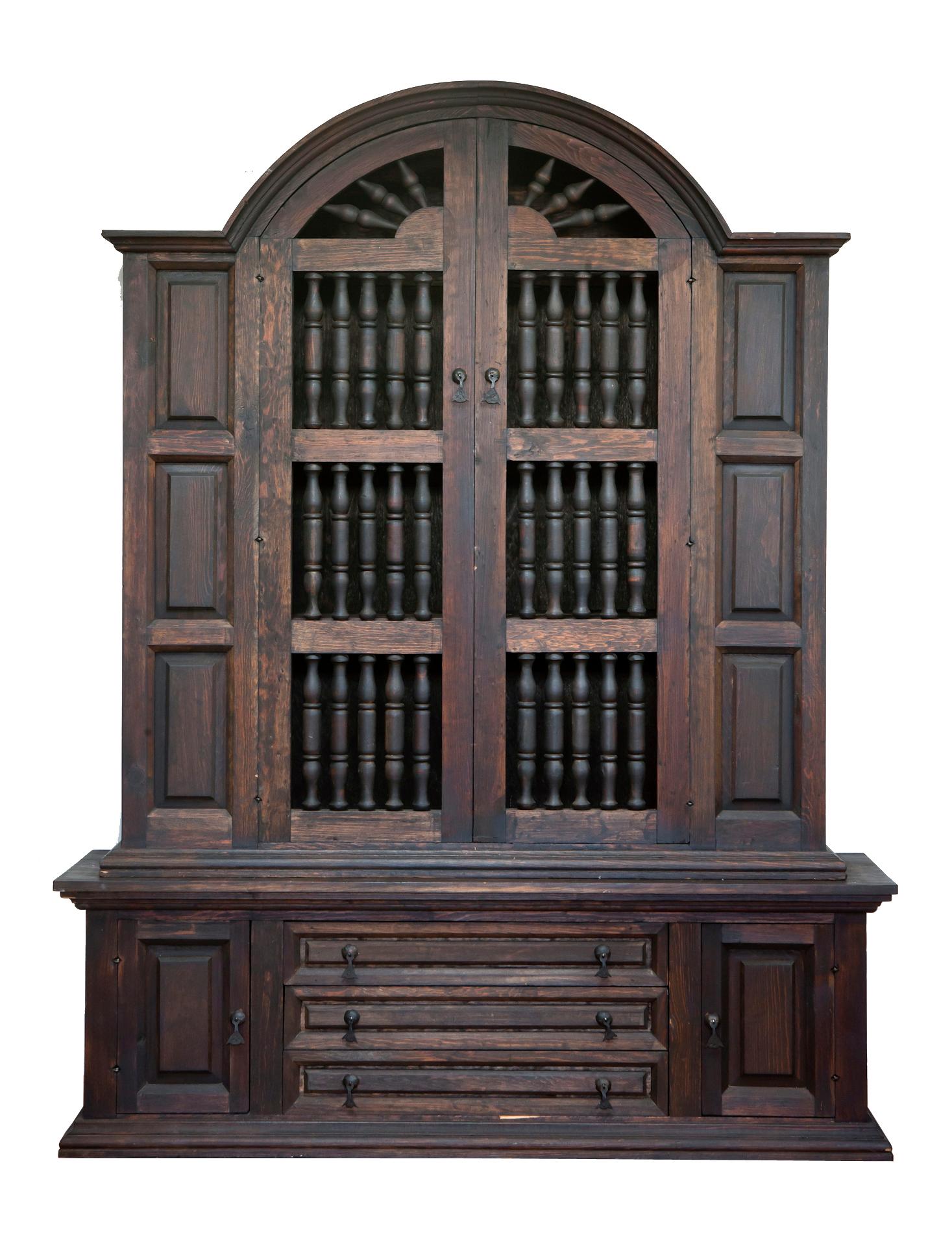 20th century Spanish style cabinet constructed from pine. The cabinet features a coffered case fronted by two decorative doors. The bottom portion has 3 center draws & doors on each side. The cabinet is fitted with handcrafted iron hardware. There