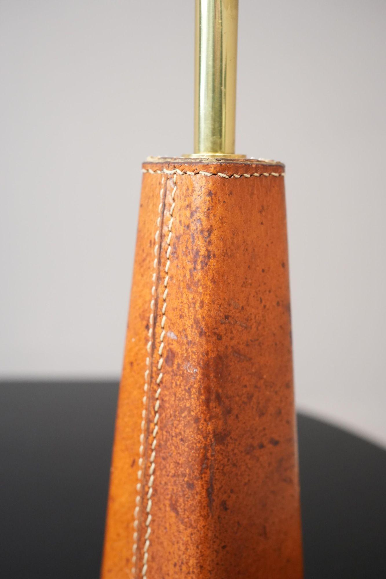 This is a very stylish and classic design table lamp. Covered in an attractively patinated tan leather. Fully re wired and has stamped makers mark on the underside.
Height 41cm Width 8cm Depth 8cm