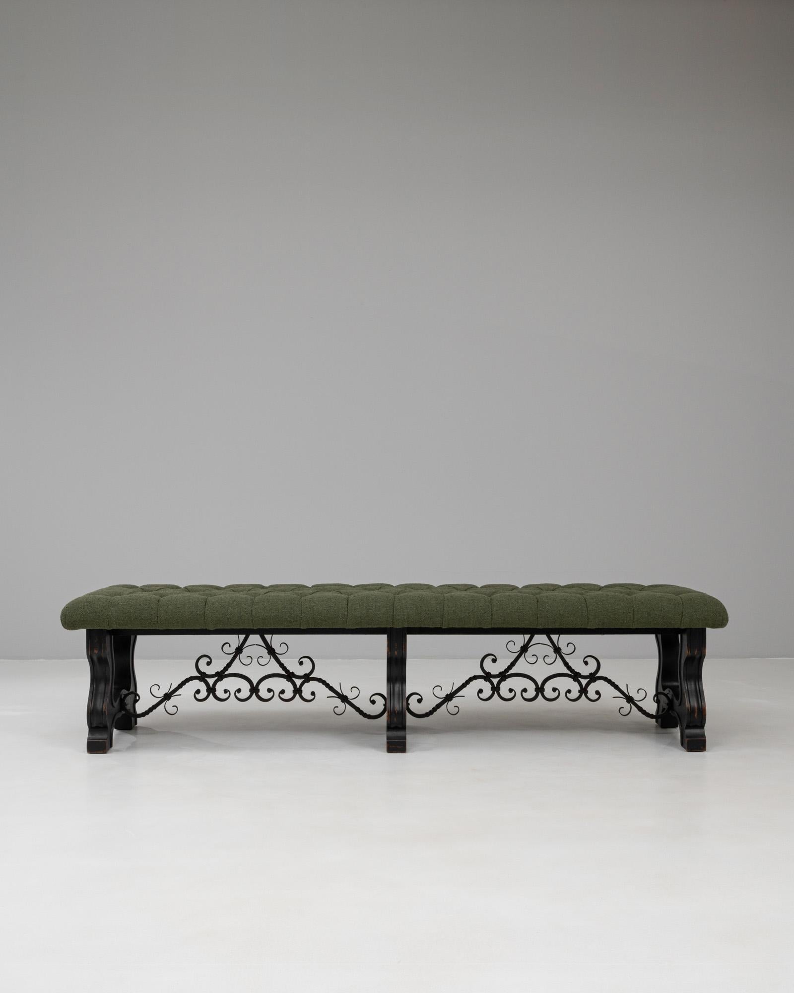 Ce banc espagnol du XXe siècle en bois et en métal combine des lignes architecturales audacieuses avec des détails décoratifs faits à la main, créant ainsi une présence frappante et substantielle. Le banc est doté d'une assise rembourrée tuftée d'un