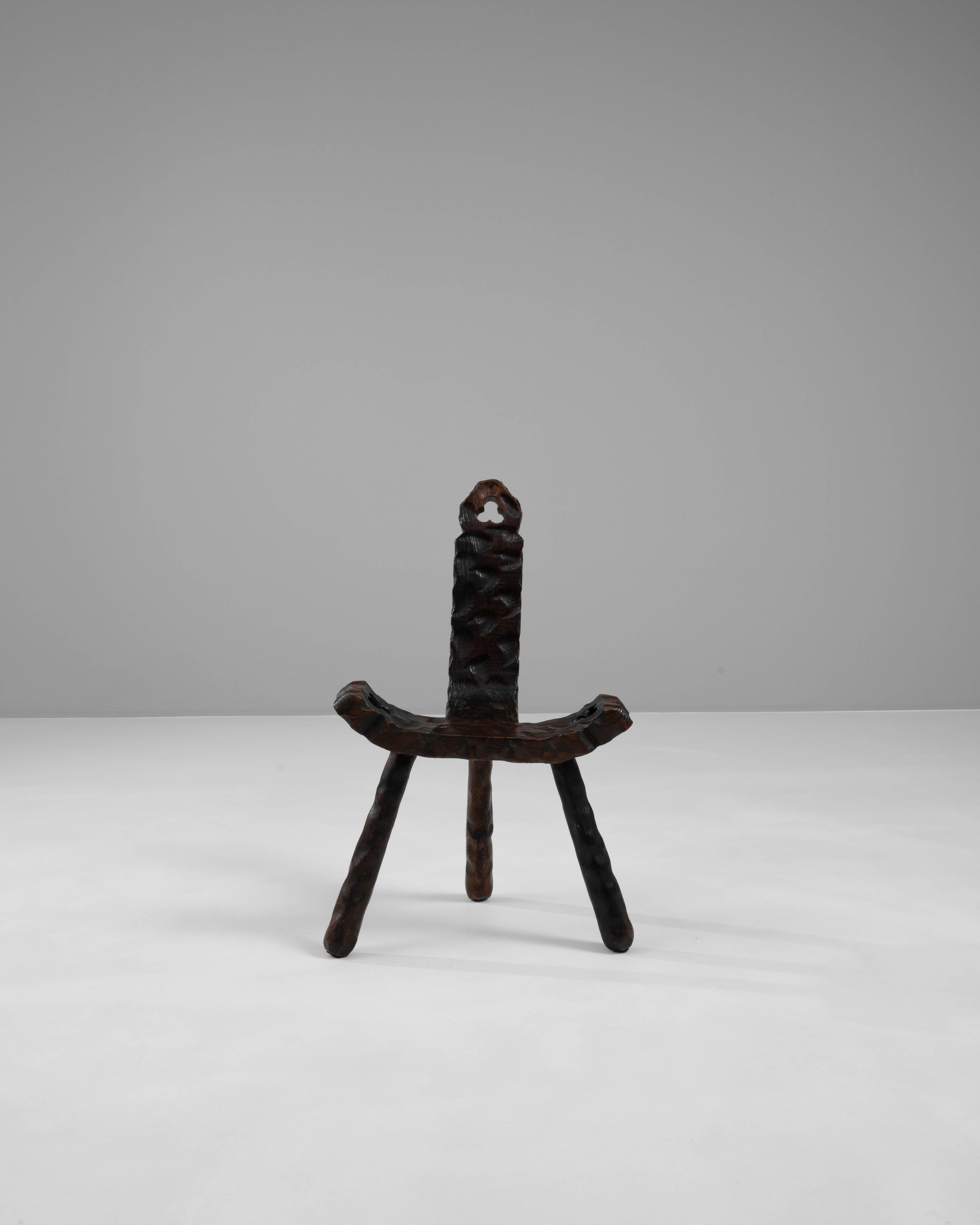 Unveil the artistry of this unique 20th Century Spanish Wooden Chair, where exceptional craftsmanship meets organic beauty. Sculpted from dark, rich wood, this chair stands out with its extraordinary, fluid design and intricate textures that mimic