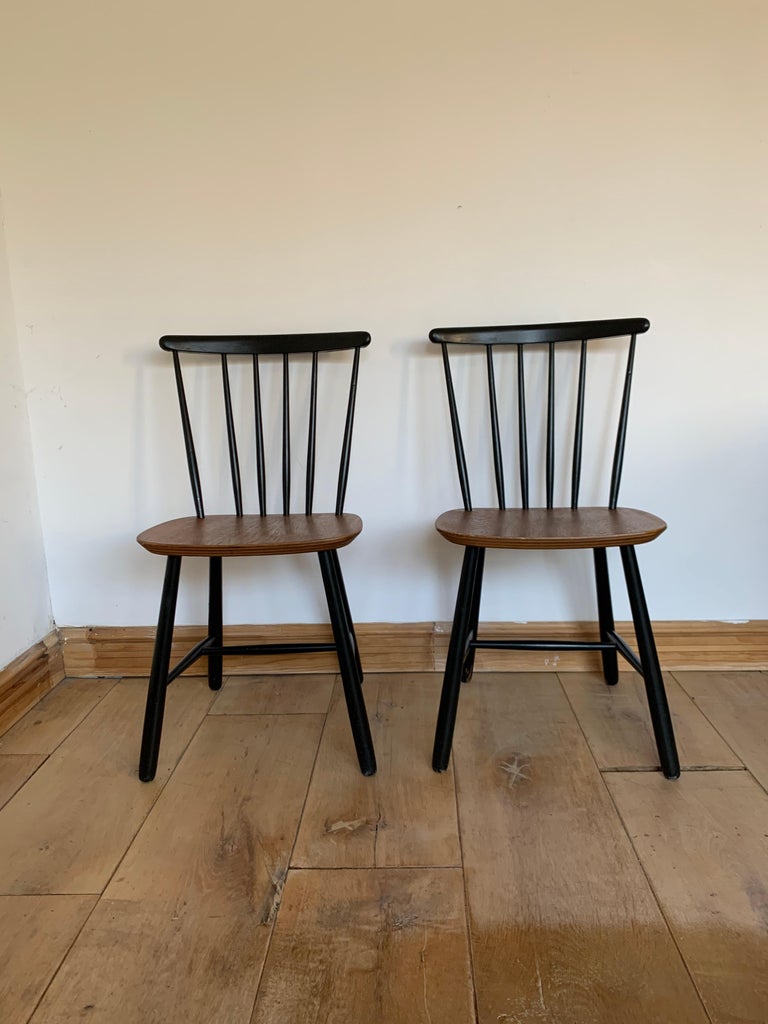 Two beautiful chairs featuring a spindle back and a teak ply seat. The chairs were made, circa 1960. There were several companies producing this type of chair in the midcentury: Edsby Verken, Pastoe and Nesto. Those chairs come from Netherlands and