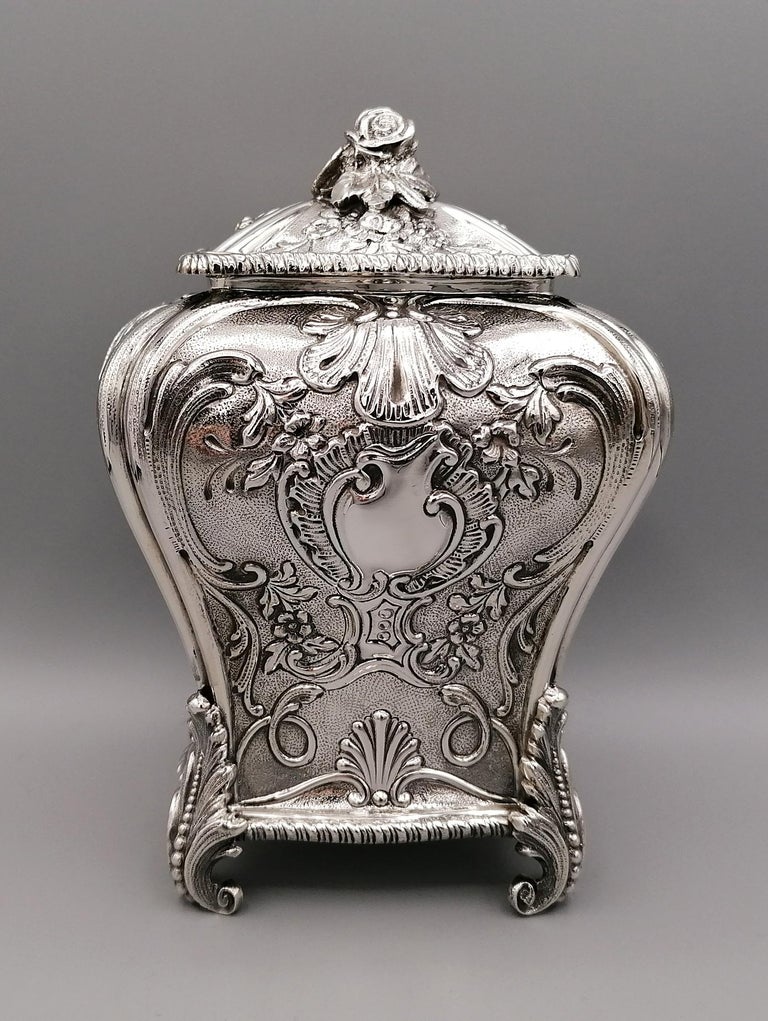 Geroge III tea caddy replica. 
Rectangular form with serpentine shaped sides, decorated with a repousse floral design, and with acanthus capped feet and floral finials. Completely handmade the teacaddy is fully embossed e godronato. The lid is a
