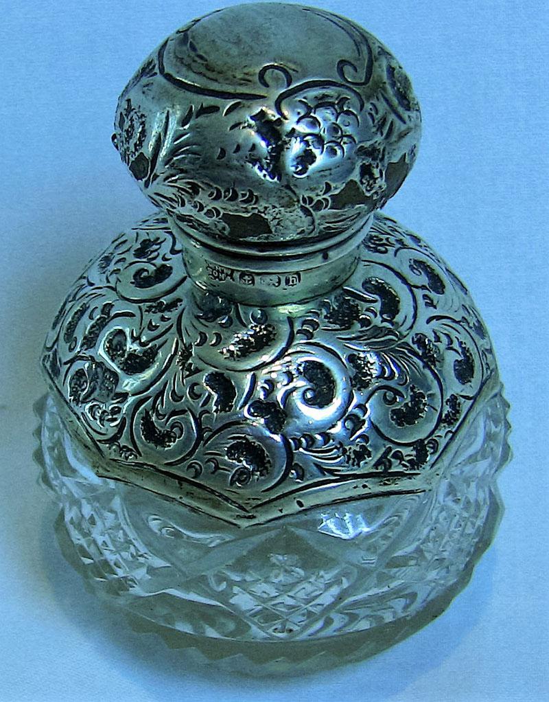 Pretty English sterling silver perfume bottle.

Stopper and base are fully Hallmarked…….H.W. & Co. Ltd, Birmingham Anchor, Lion passant, and letter “h”.

The stopper screws off and still retains its original cork.

Beautiful repousse work
