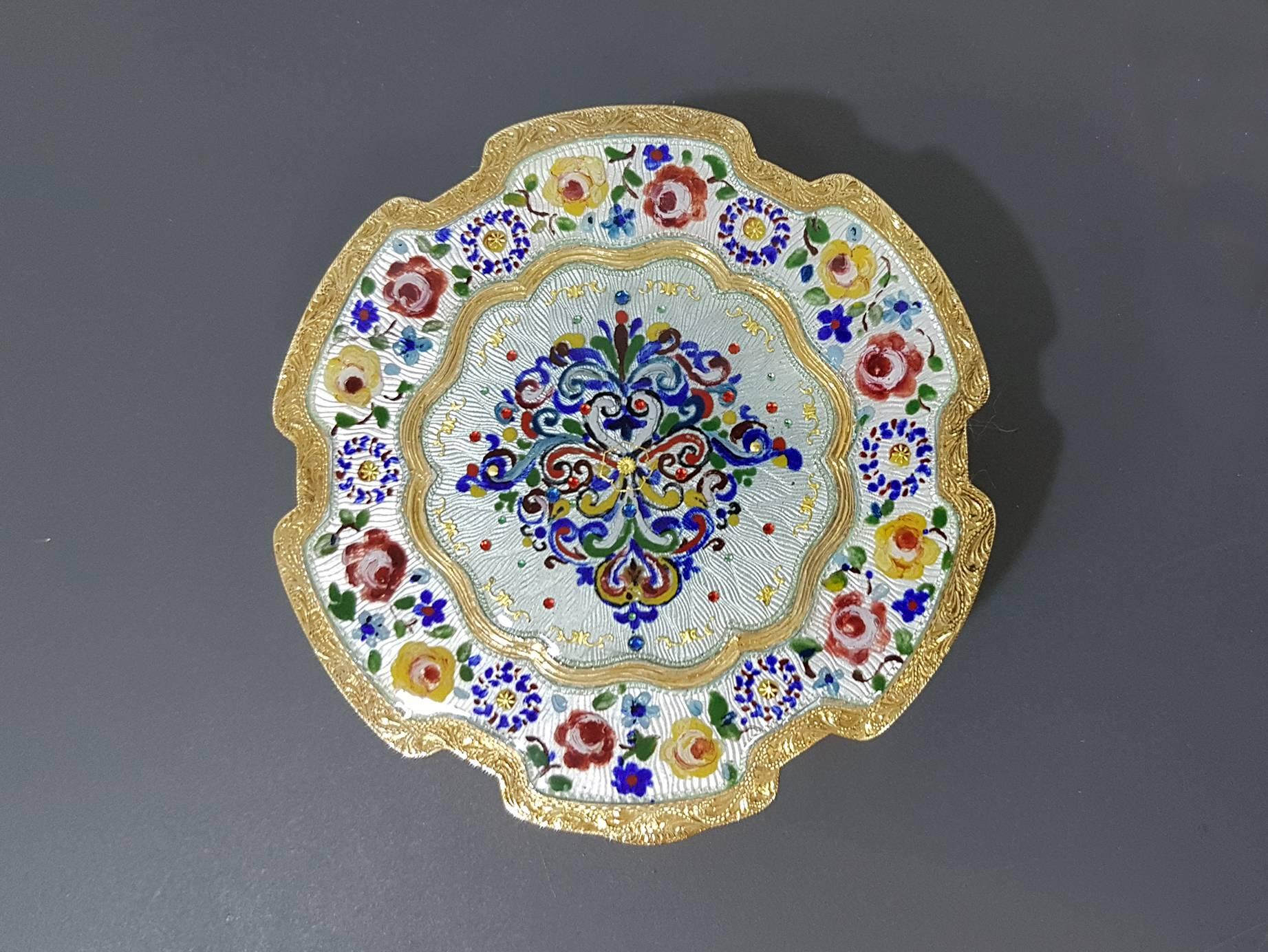Round shaped box Made in Italy Silver Gilted 925/1000 with translucent enamels on guilloche with hand painted floral miniatures and gold paillons

The Miniatures are hand-painted on a usually white homogeneous enamel base. The same colored glazes