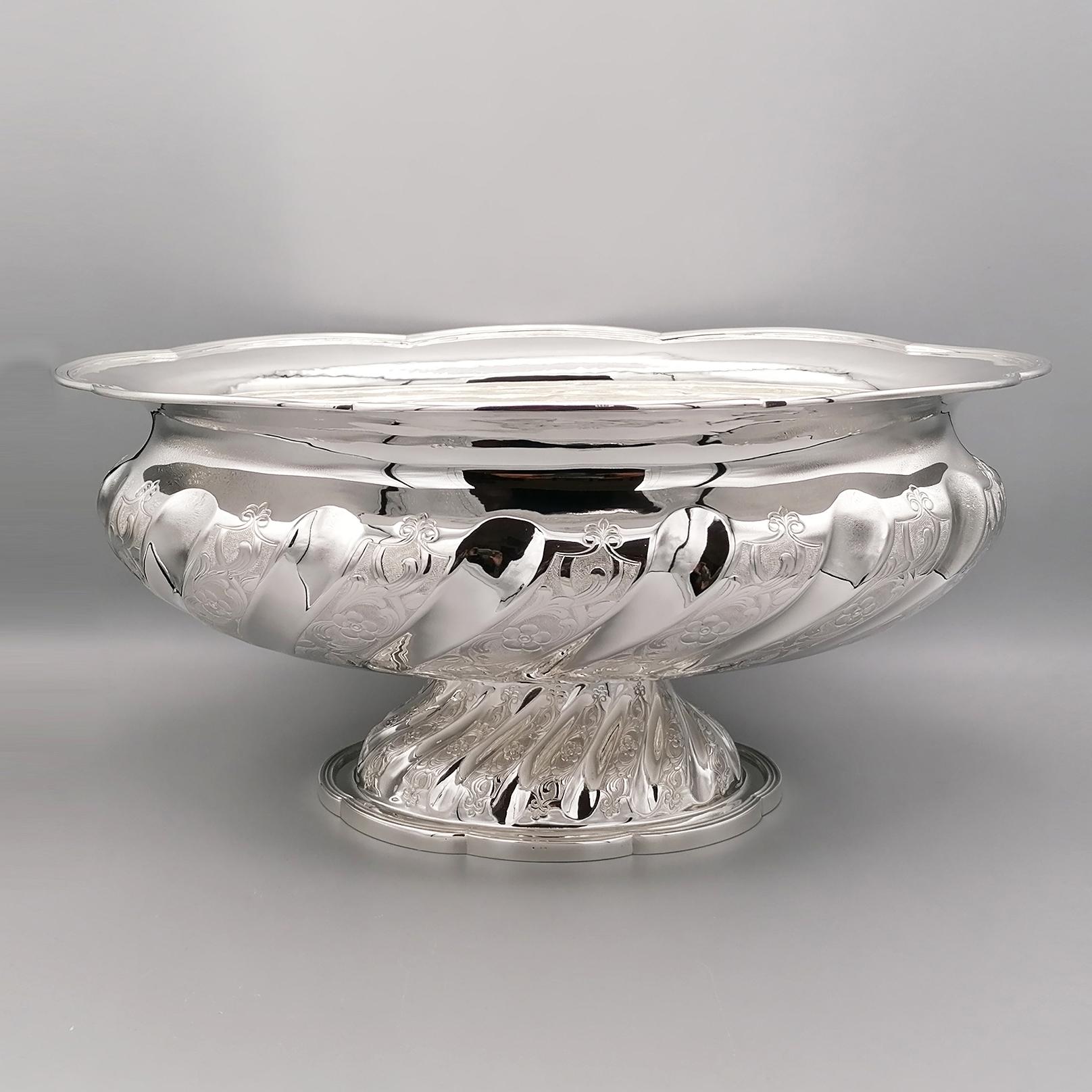 Entirely handmade solid sterling silver centerpiece. 
The shaped and edged oval bowl with a double line rim, rests on a foot which is also oval shaped.
The body of the centerpiece is torchon chiseled.
The torchon is interspersed with a concave shiny
