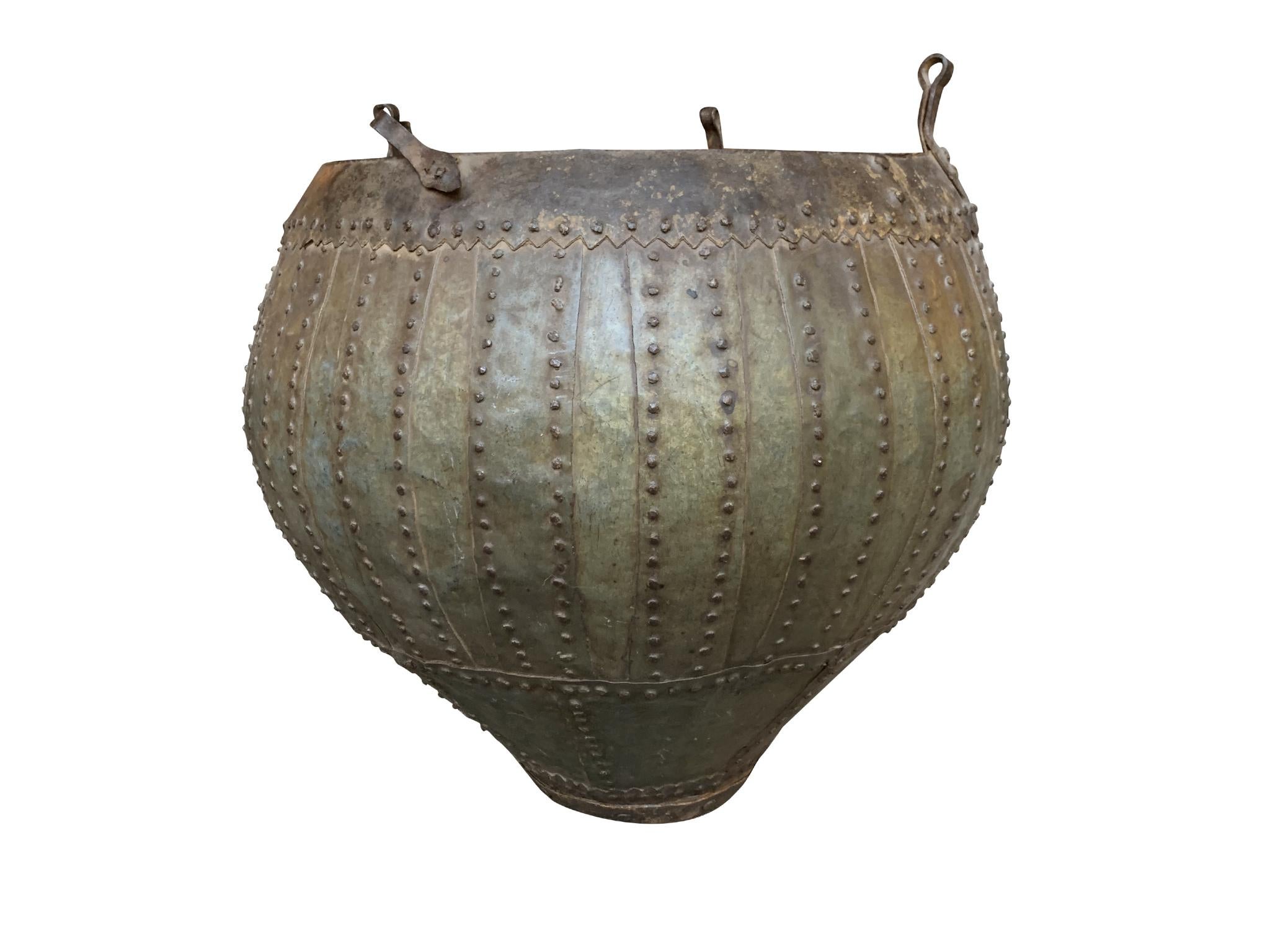 A large 20th Century urn comprised of hammered, studded brass and bronze. Its spare, industrial structure is reminiscent of Brutalist design. 

Dimensions:
24 in. diameter
22.5 in. height to rim
25 in. height to top of hook