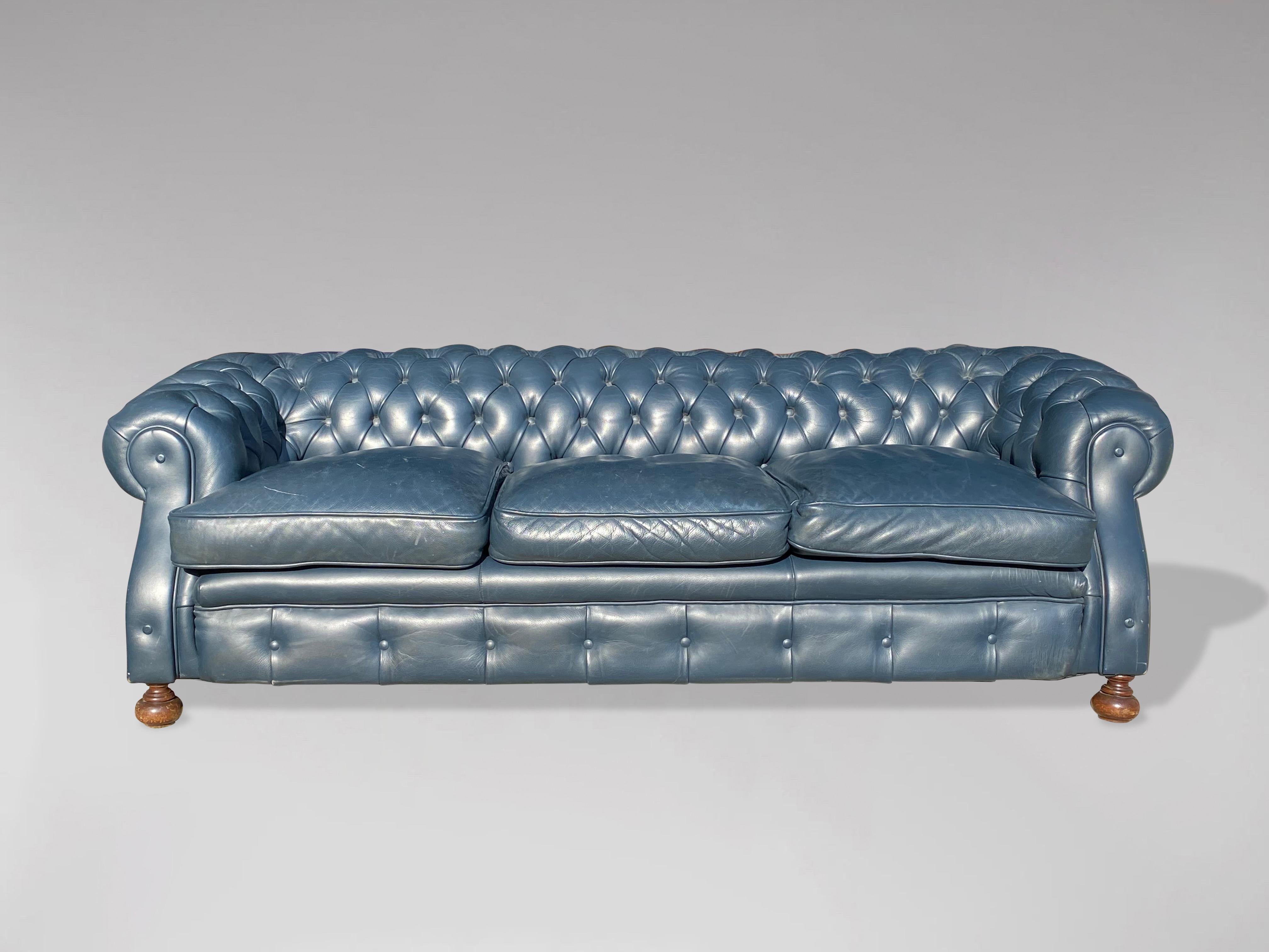 A superb quality 20th century large three seater blue leather chesterfield with three loose feathered cushions, raised on 5 bun feet. A fine example of a good quality with a good patina comfortable chesterfield. With the original quality blue