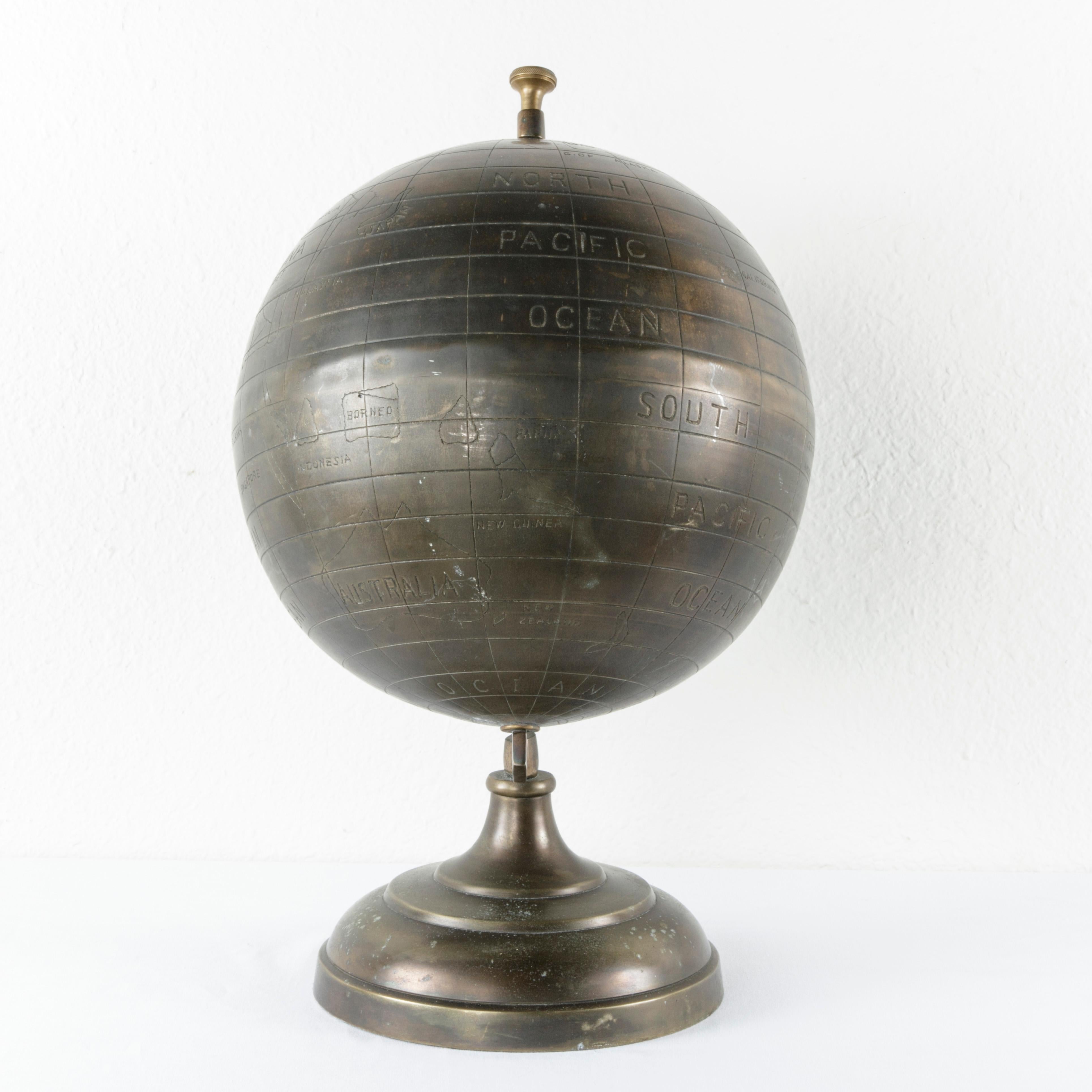 Found in France, this 20th century handmade bronze globe features stylized etched borders, latitudes, and longitudes with land masses and waters labeled in English. This globe can be dated to the 1980s evidenced by the countries of Zaire and