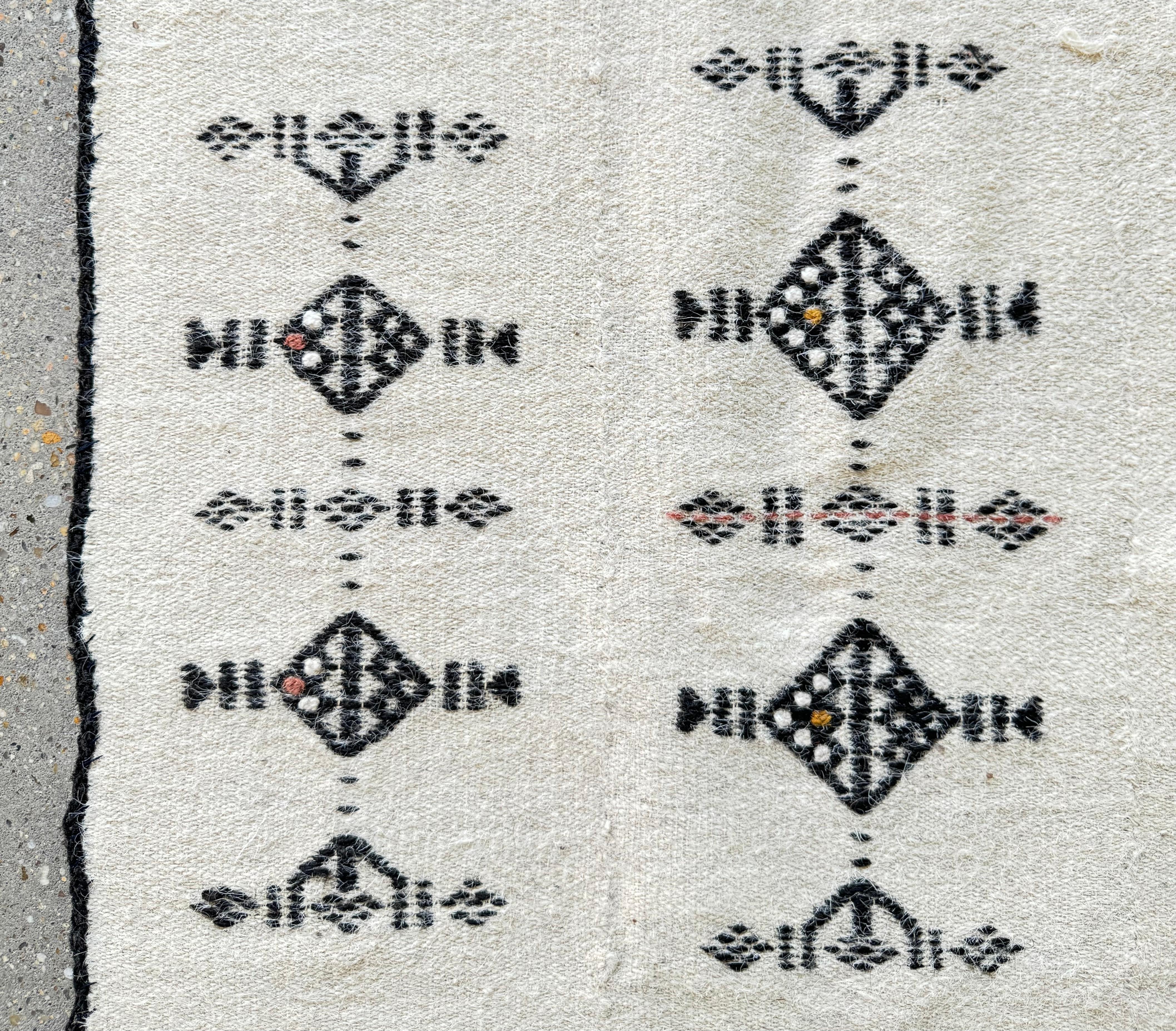 Handwoven using traditional techniques, the materials include locally sourced wool. The use of wool provides warmth and durability, making these textiles suitable for various purposes.

The design of the textile features a combination of geometric