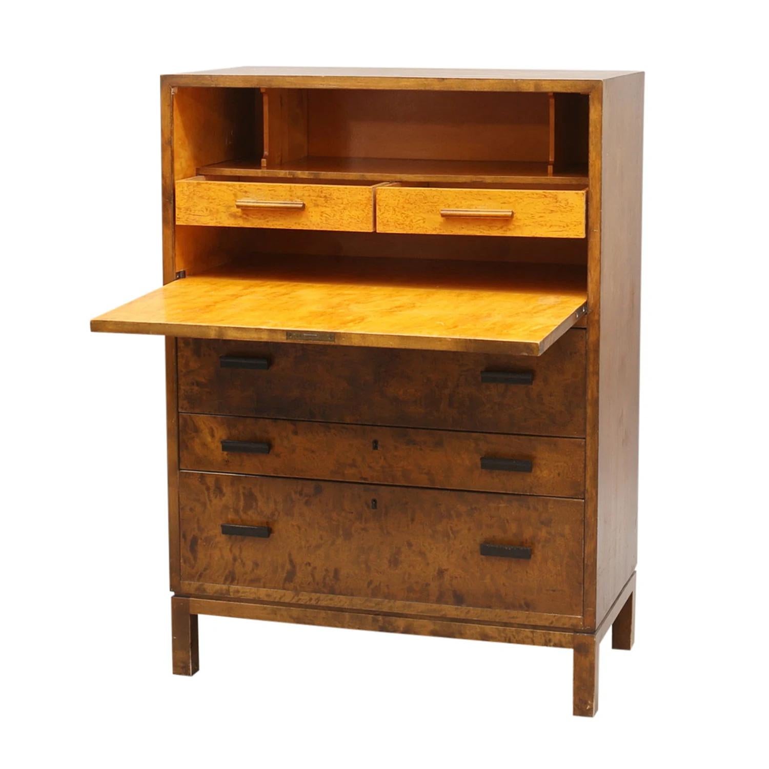 A vintage Swedish Art Deco secretary made of hand crafted polished, partly veneered Birchwood, designed most likely by Axel Larsson in good condition. The Scandinavian cupboard, cabinet is composed with a writing a flap and two large and one small