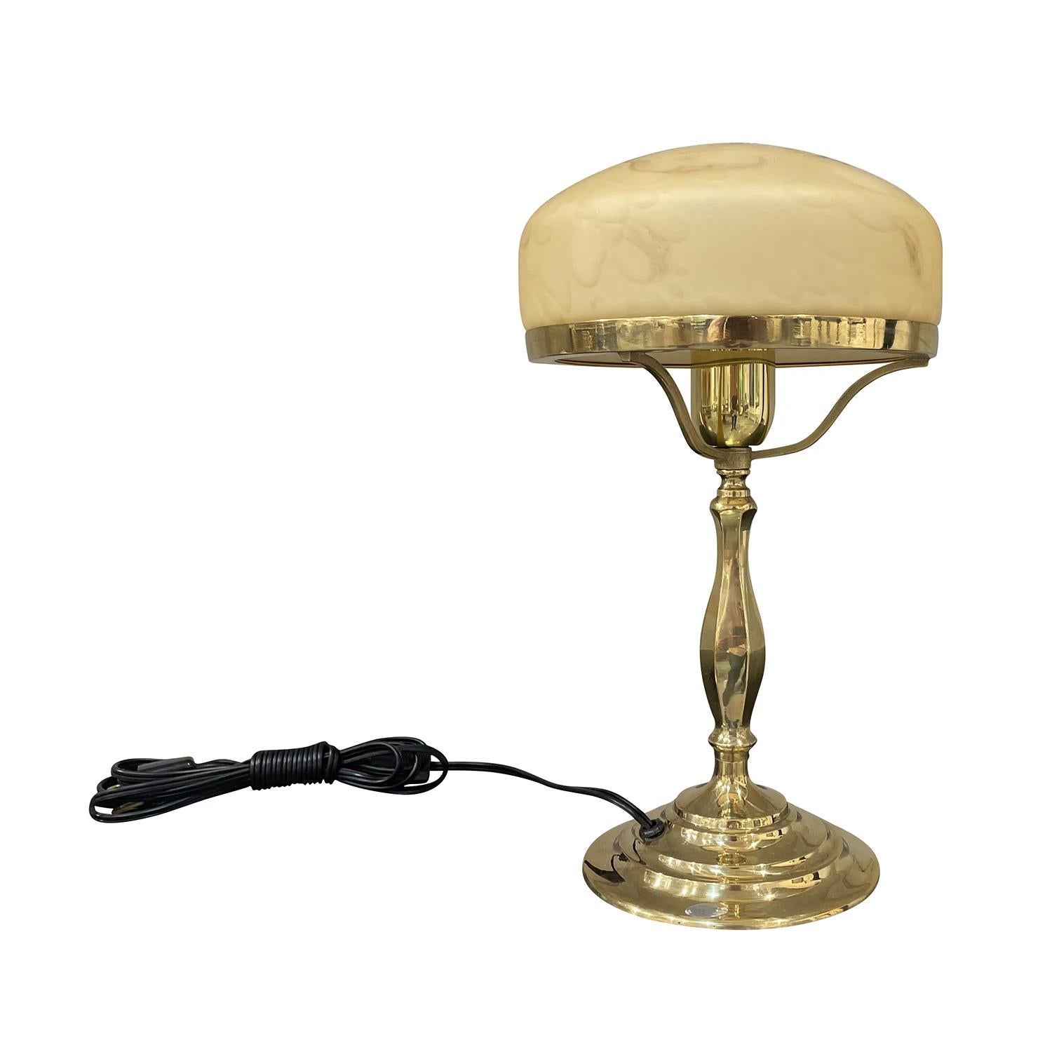A gold, vintage Mid-Century Modern Swedish sculptural desk lamp made of hand crafted polished brass, produced by AB Markaryd in good condition. The small Scandinavian table light is composed with a round yellow smoked shade, made of hand blown