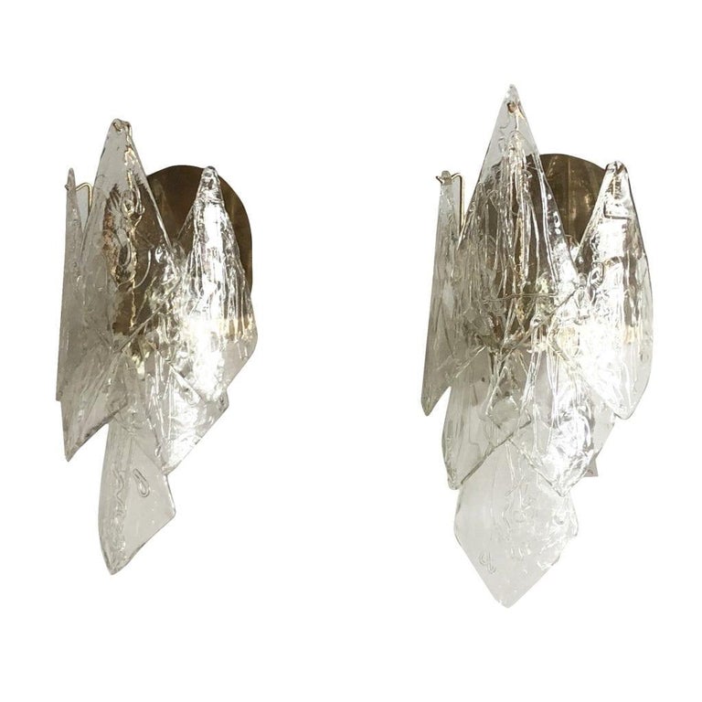 A vintage Mid-Century Modern Swedish pair of Acanthus leaf wall sconces made hand blown crystal glass and supported by a brass structure. The Scandinavian wall appliques were designed by Carl Fagerlund and produced by Orrefors, featuring a three