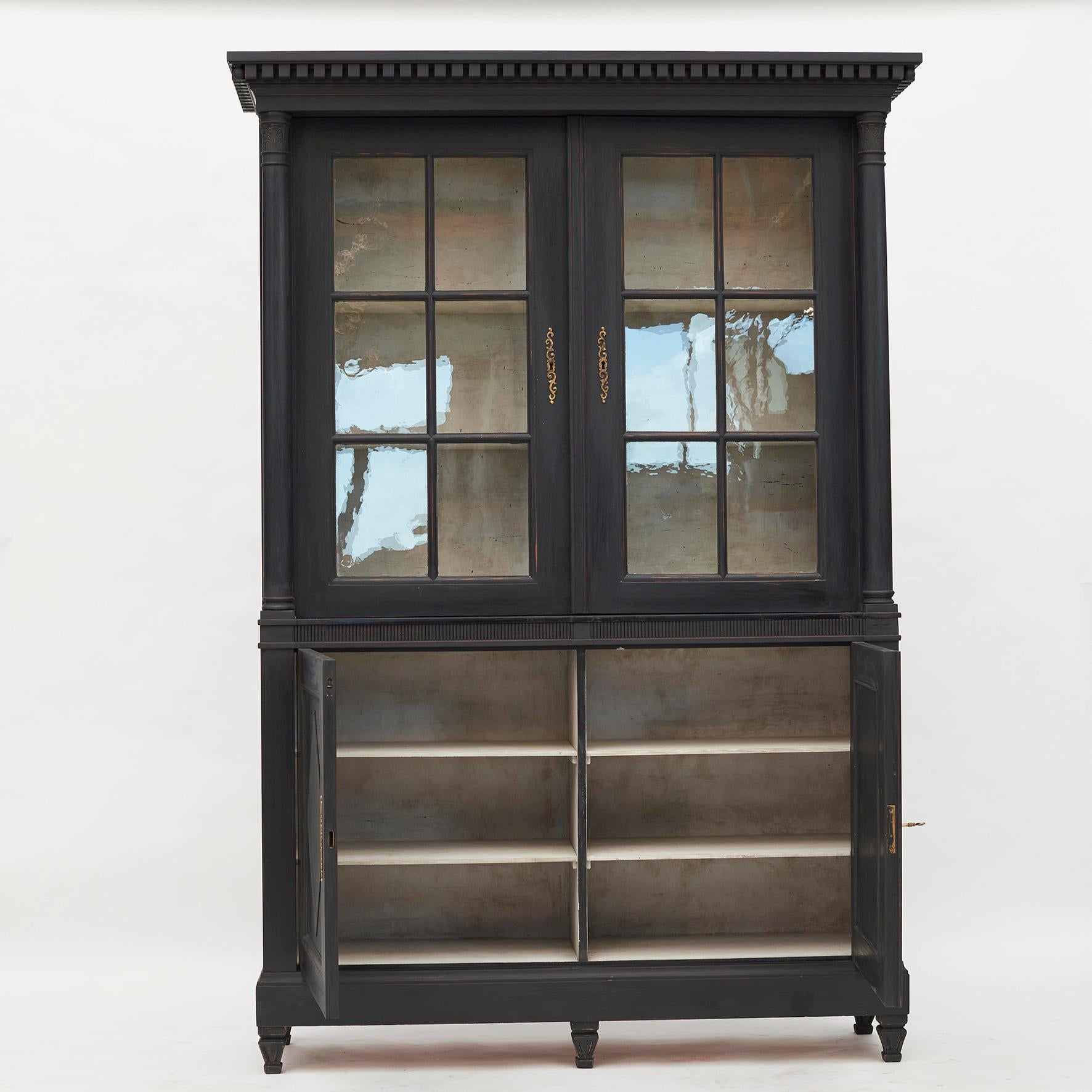 A Beautiful Gustavian 4-doors glass and wood cabinet. Pair of locking paned glass doors sitting atop pair of locking wood doors with rhombus motif fillings. Black painted wood with light grey color inside. Brass fittings, 1 key. Gustavian style,