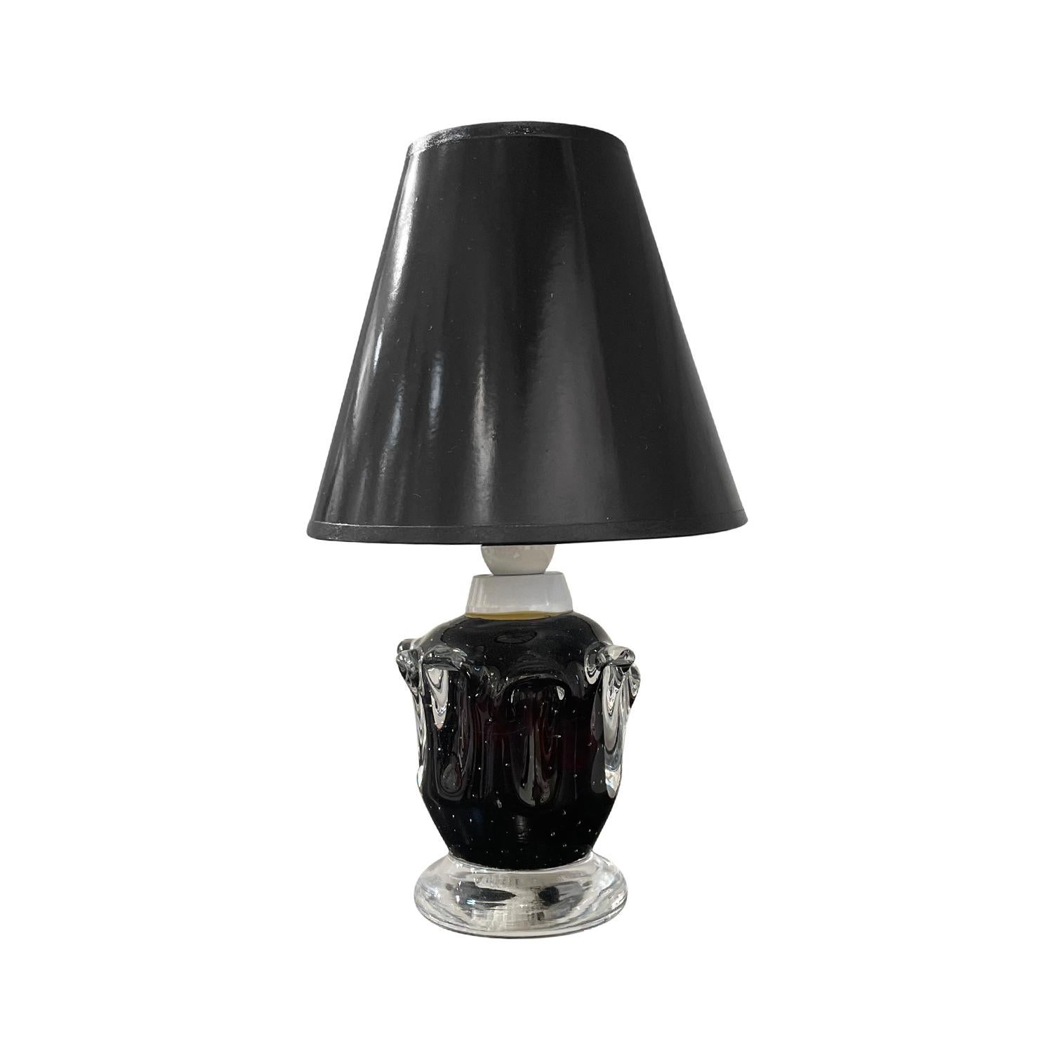 A sculptural, vintage Mid-Century Modern Swedish table lamp with a new black shade, made of hand blown Orrefors glass, featuring a one light socket in good condition. The small dark-brown, black undercoat Scandinavian desk light was designed,