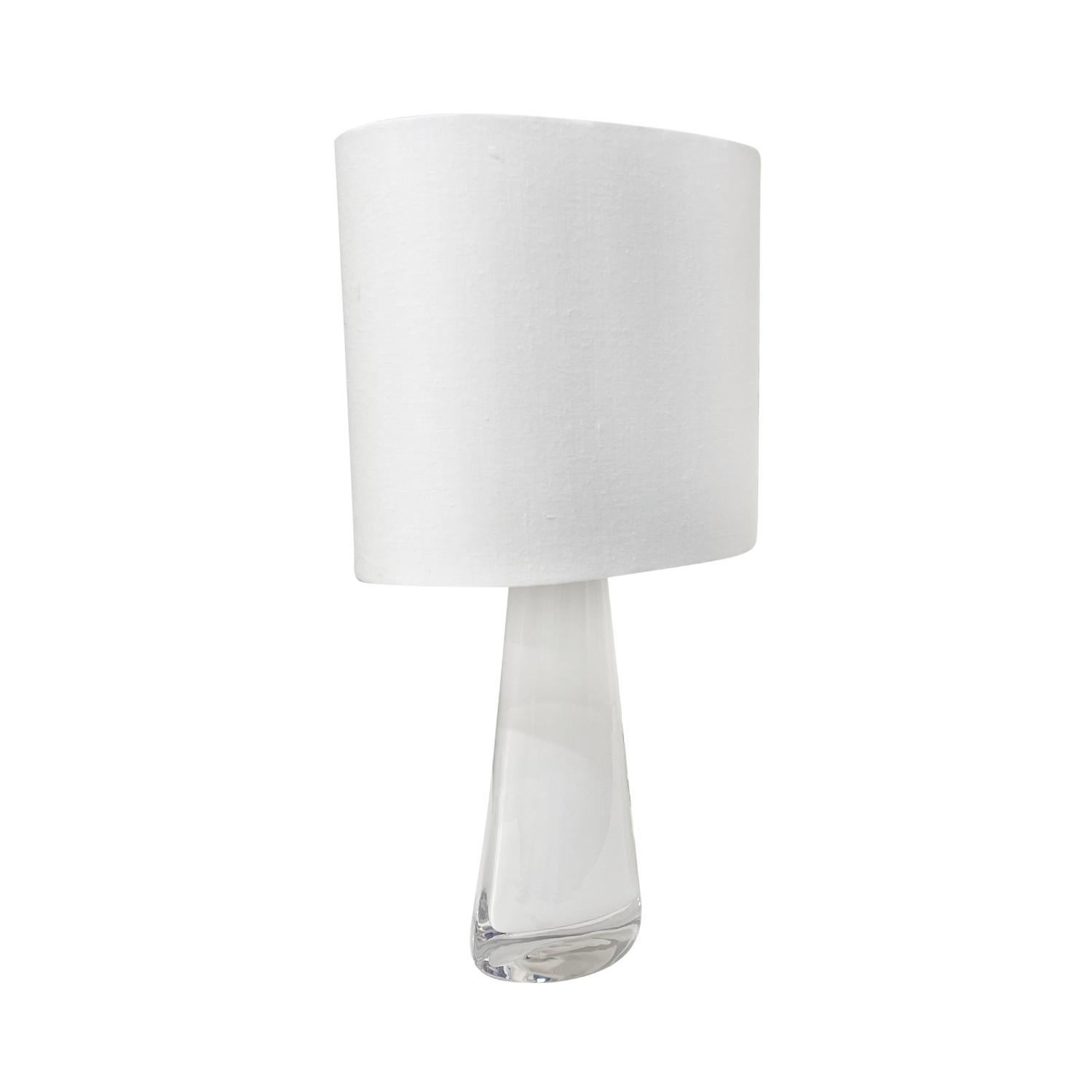 A half round, vintage Mid-Century Modern Swedish table lamp with a new white oval shade, made of hand blown Orrefors glass, the beam is enhanced with a chrome ring, featuring a one light socket in good condition. The white undercoat Scandinavian
