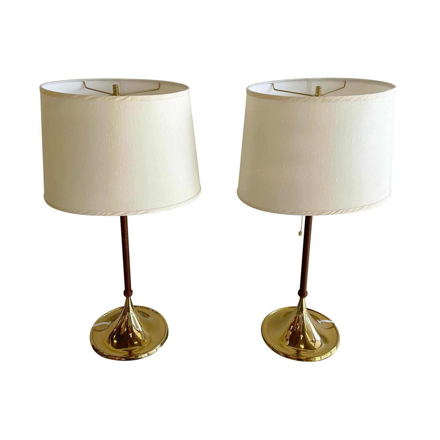 A vintage Mid-Century Modern Swedish pair of table lamps with a new white-yellow oval shade made of hand crafted polished brass, designed most likely by Alf Svensson & Yngve Sandström and produced by Bergboms in good condition. The stem of the