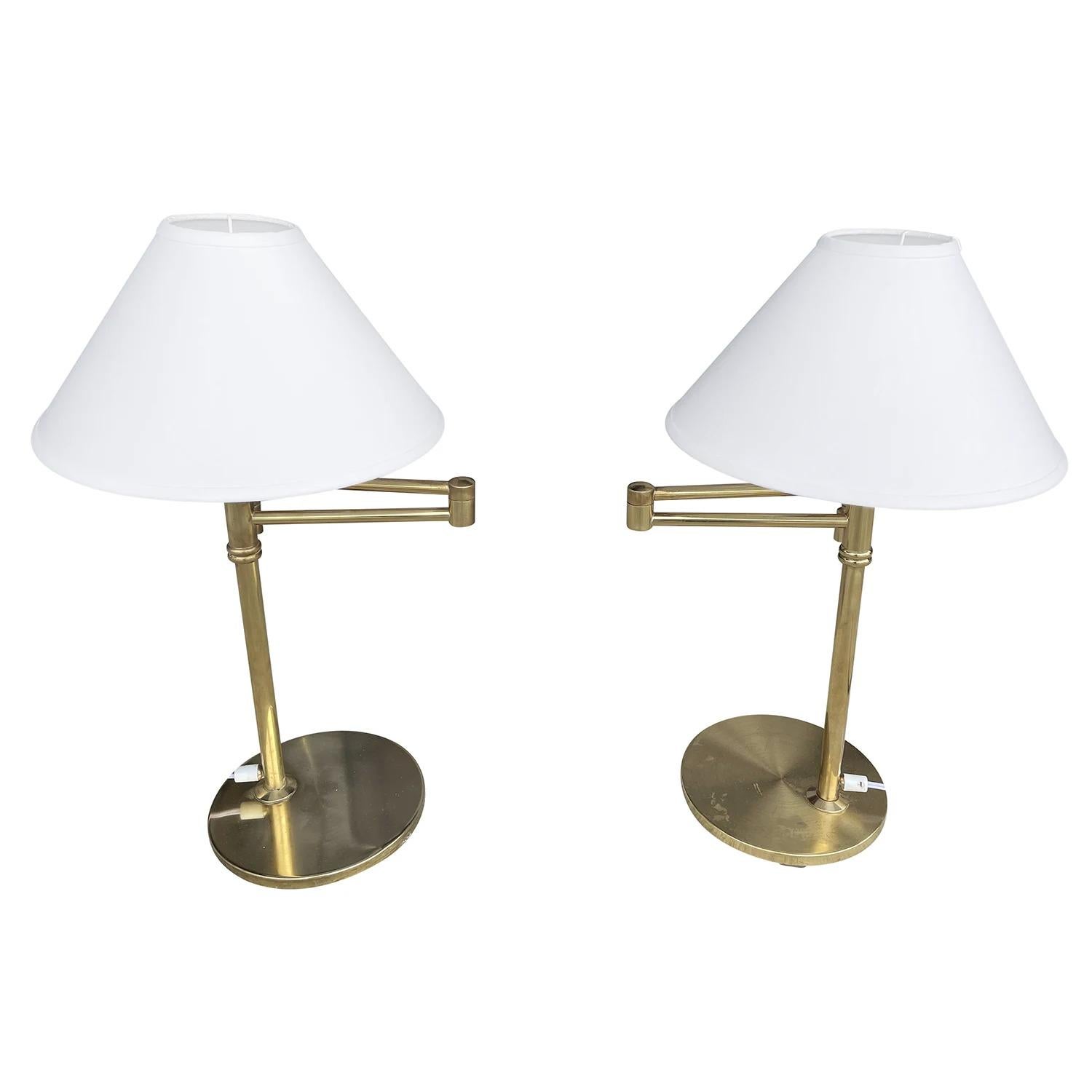 A vintage Mid-Century Modern Swedish pair of reading table lamps made of hand crafted polished brass, produced by EWÅ, Värnamo in good condition. The two long flexible, adjustable arms of the Scandinavian desk lights are ideally for reading,