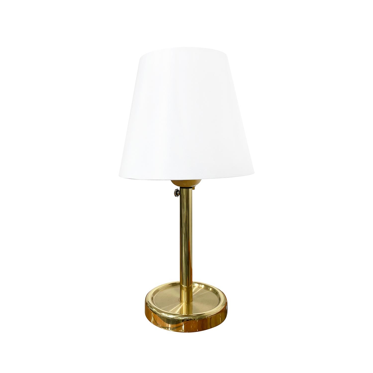 A vintage Mid-Century modern Swedish table lamp with a new white round shade made of hand crafted polished brass, designed and produced by Fagerhults Belysning in good condition. The Scandinavian desk light is composed with its original chrome light