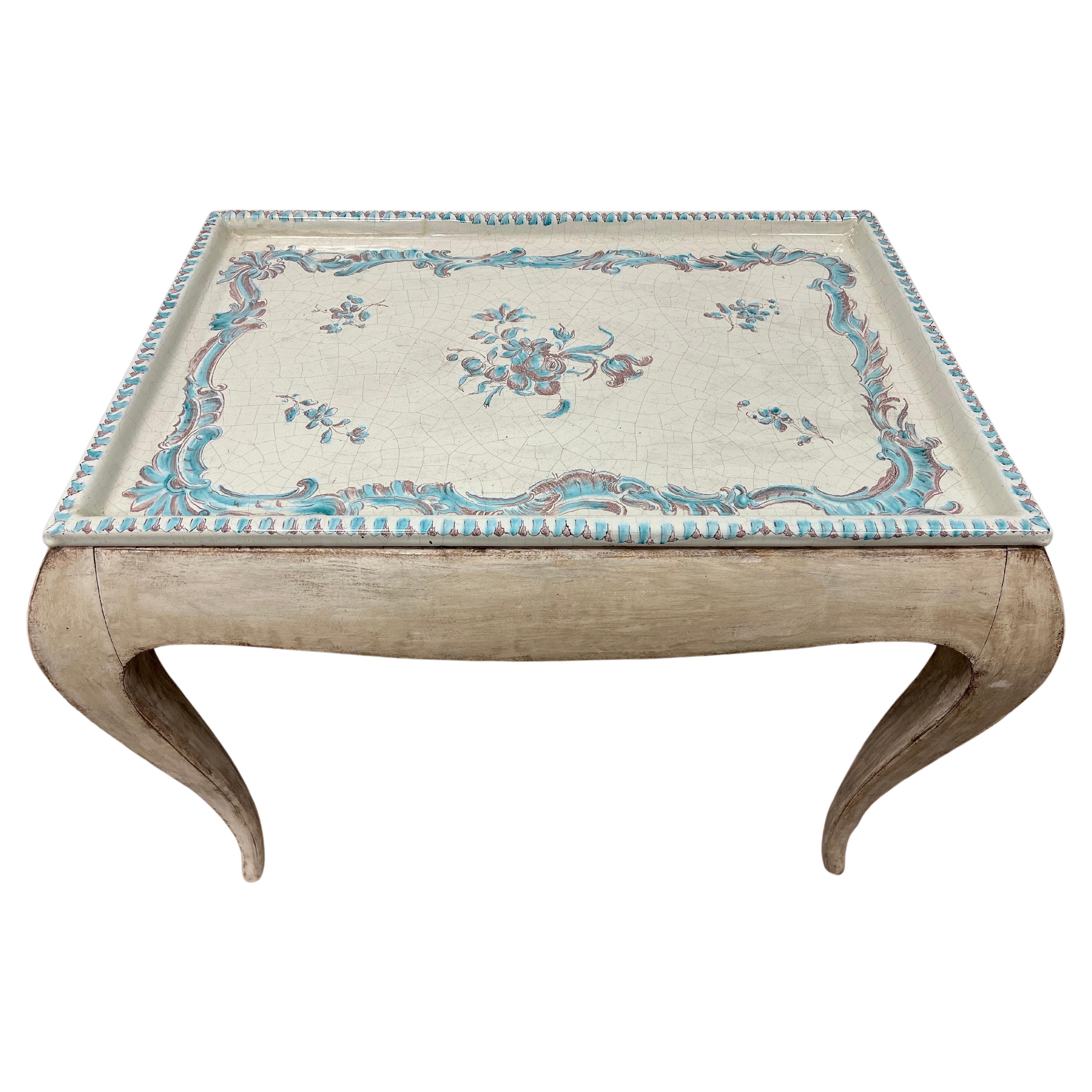 A Rococo style table with Upsala Ekeby porcelain tray top. Simple frame with cabriole legs In original cream paint.
