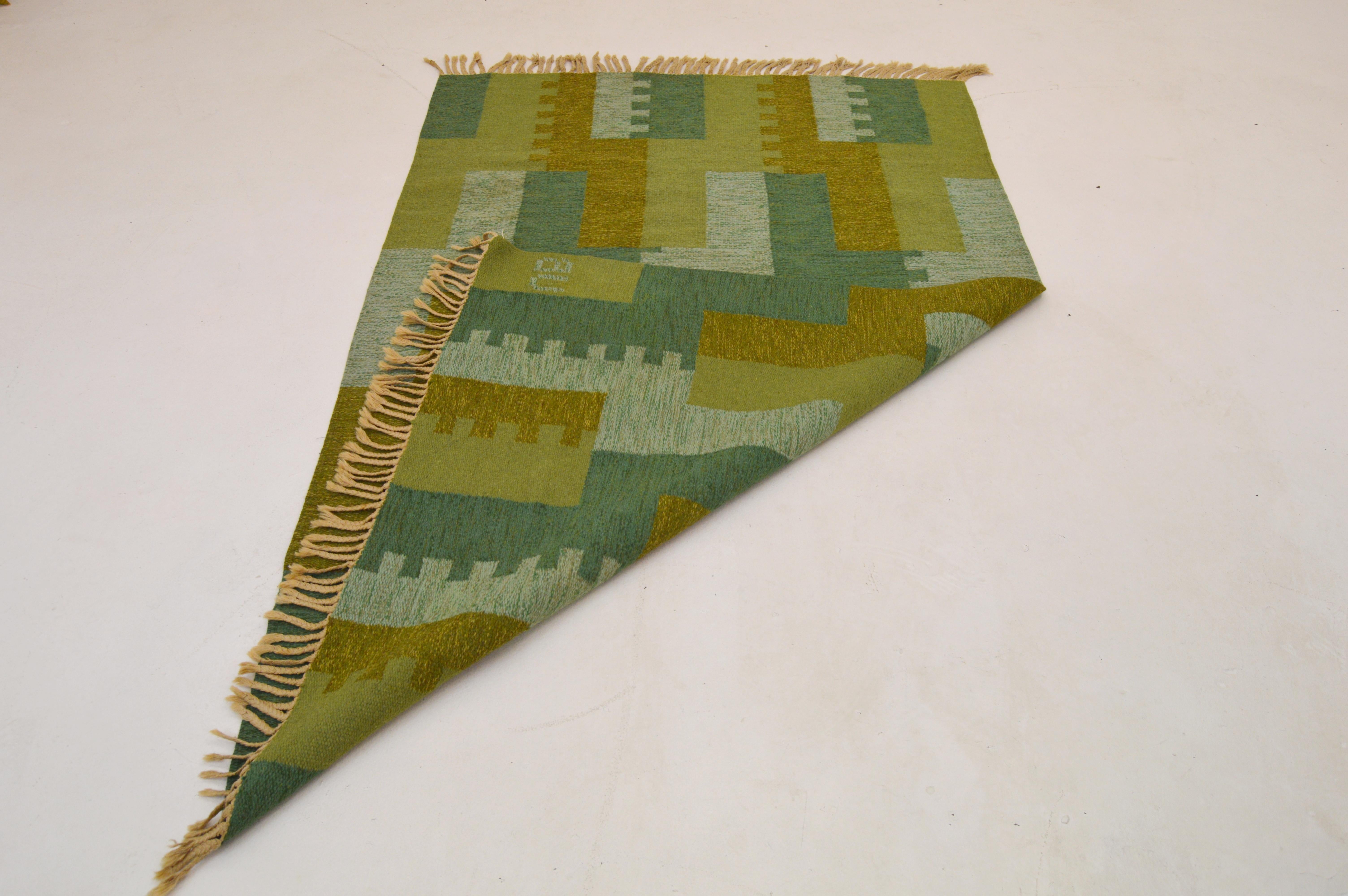 Nice vintage flat-weave rug made in Sweden during the 1950-1960s, midcentury period most likely produced in Sweden by the Swedish artist Ulla Brandt, who also made rugs for AB MMF for a period. 

Handwoven wool. Different shades of light green,