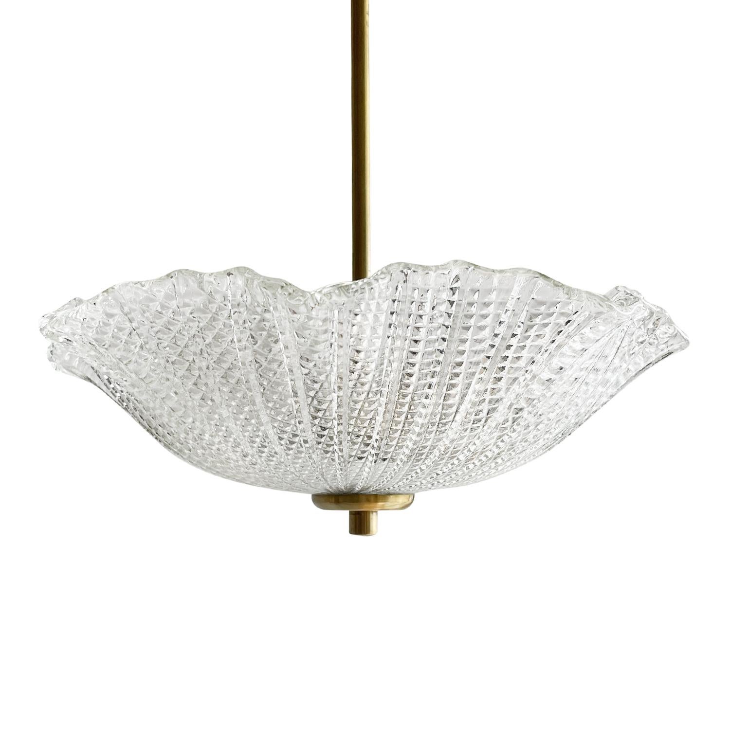 A small, vintage Mid-Cenutry modern Swedish ceiling light, lamp made of hand blown frosted glass, attributed to Orrefors in good condition. The round Scandinavian pendant is supported by a long polished brass arm, featuring a two light socket. The