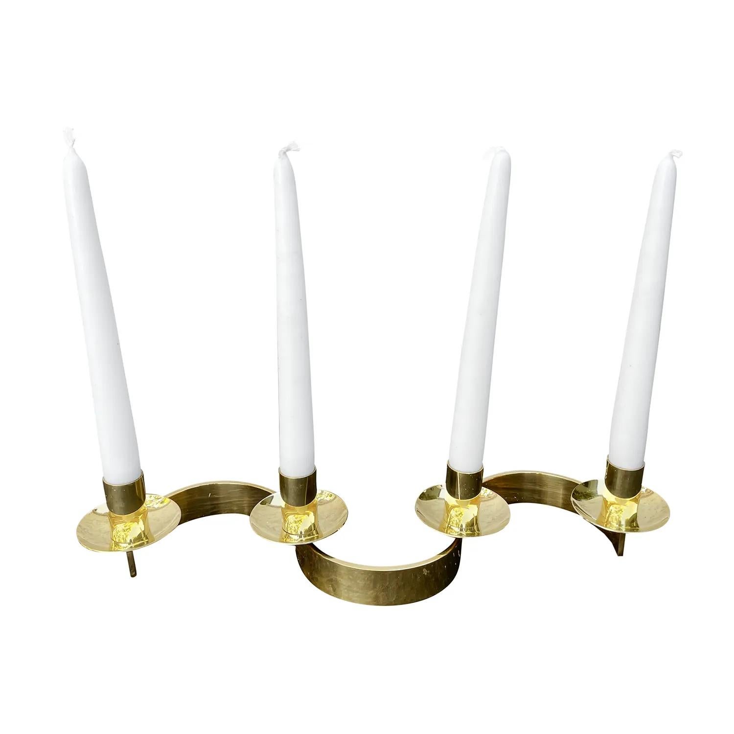 A gold, vintage Mid-Century Modern Swedish Slingan, candle holder made of handcrafted polished brass, designed by Josef Frank and produced by Svenskt Tenn in good condition. Each of the candlesticks of the Scandinavian holder is supported by a