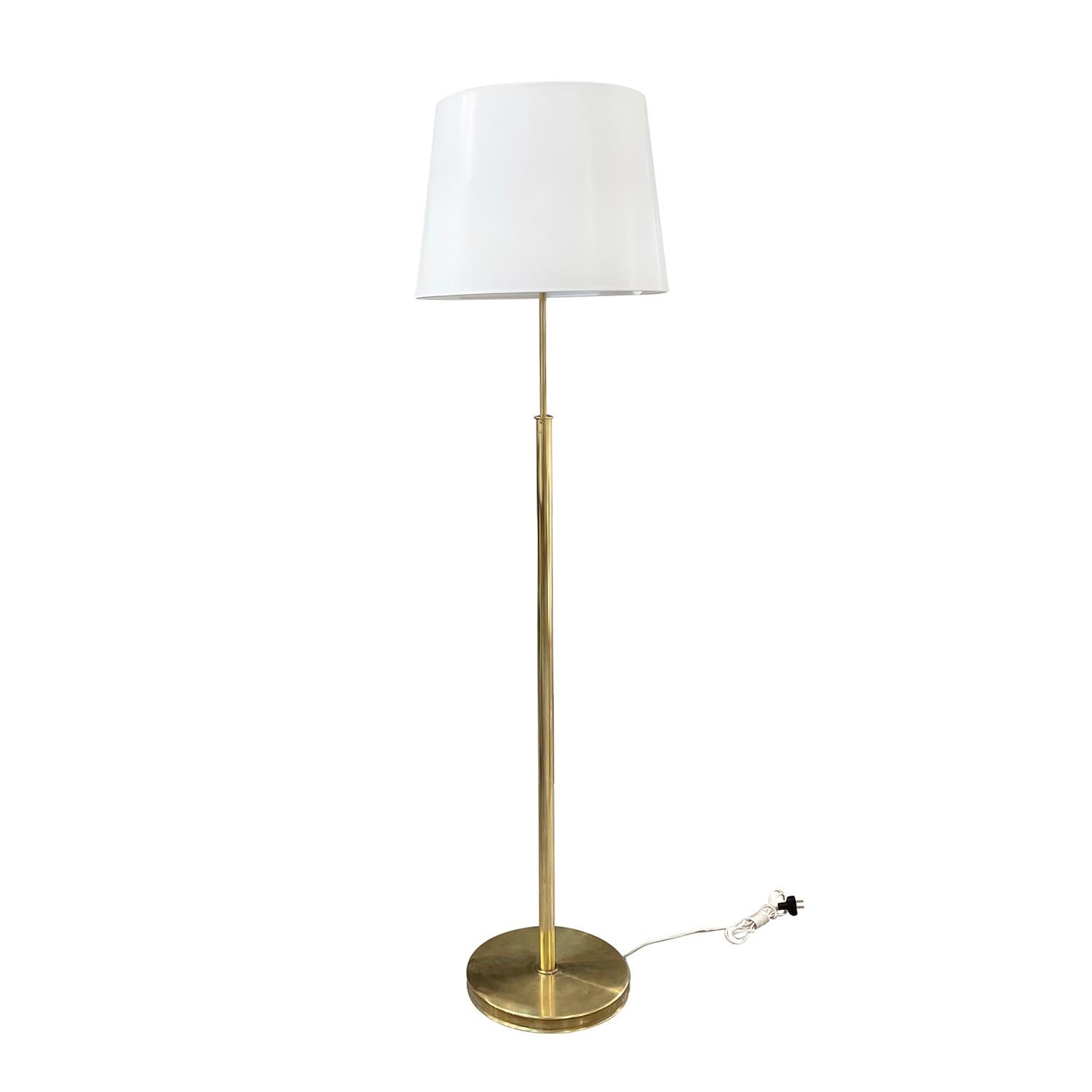 A vintage Mid-Century Modern Swedish reading floor lamp with a new withe round shade made of hand crafted polished brass, composed with its original light switches, designed by Josef Frank and produced by Svenskt Tenn in good condition. The
