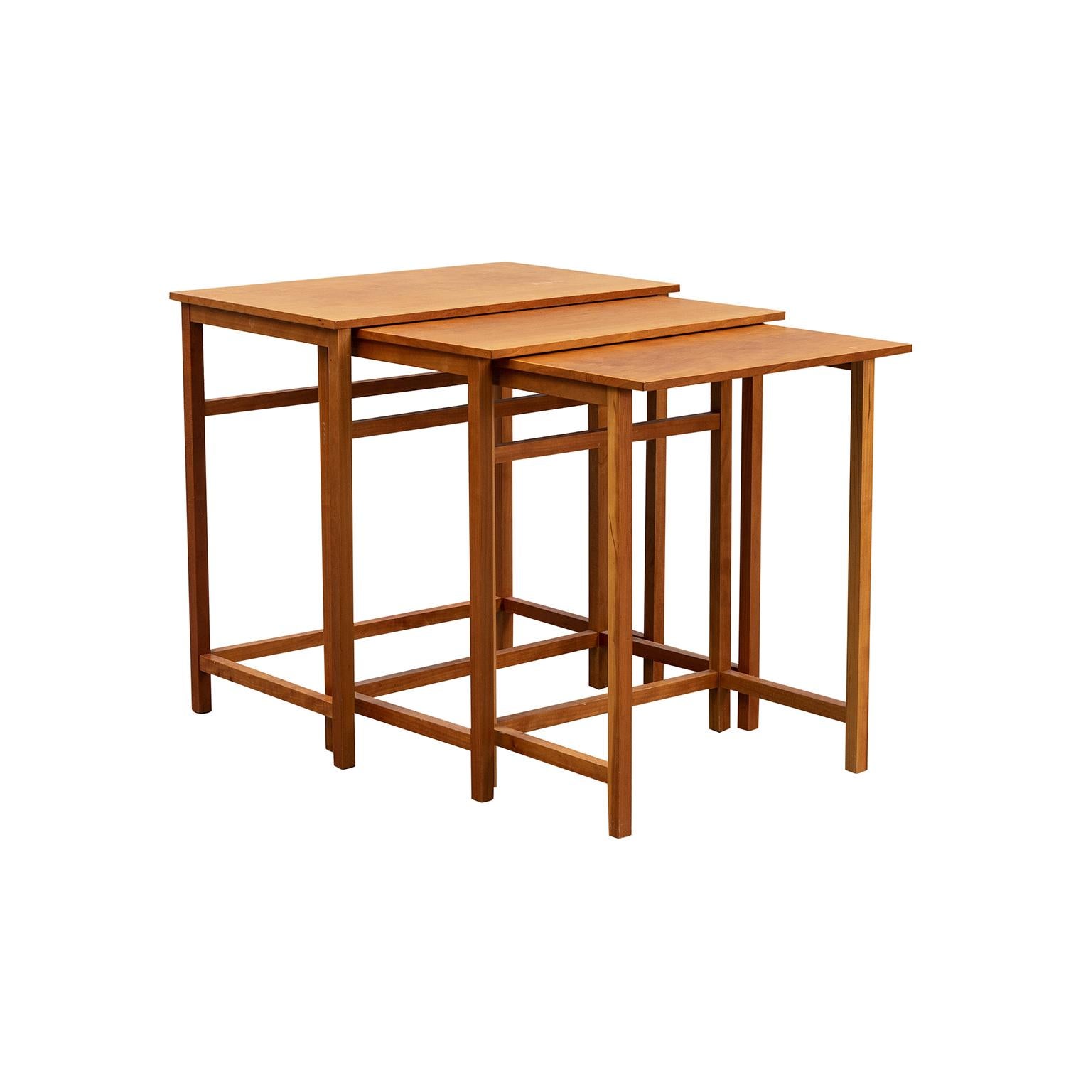 A light-brown, vintage Mid-Century Modern Swedish set of three nesting tables, model 618 made of hand carved Cherrywood, designed by Josef Frank and produced by Svenskt Tenn, in good condition. Each of the Scandinavian side tables are standing on